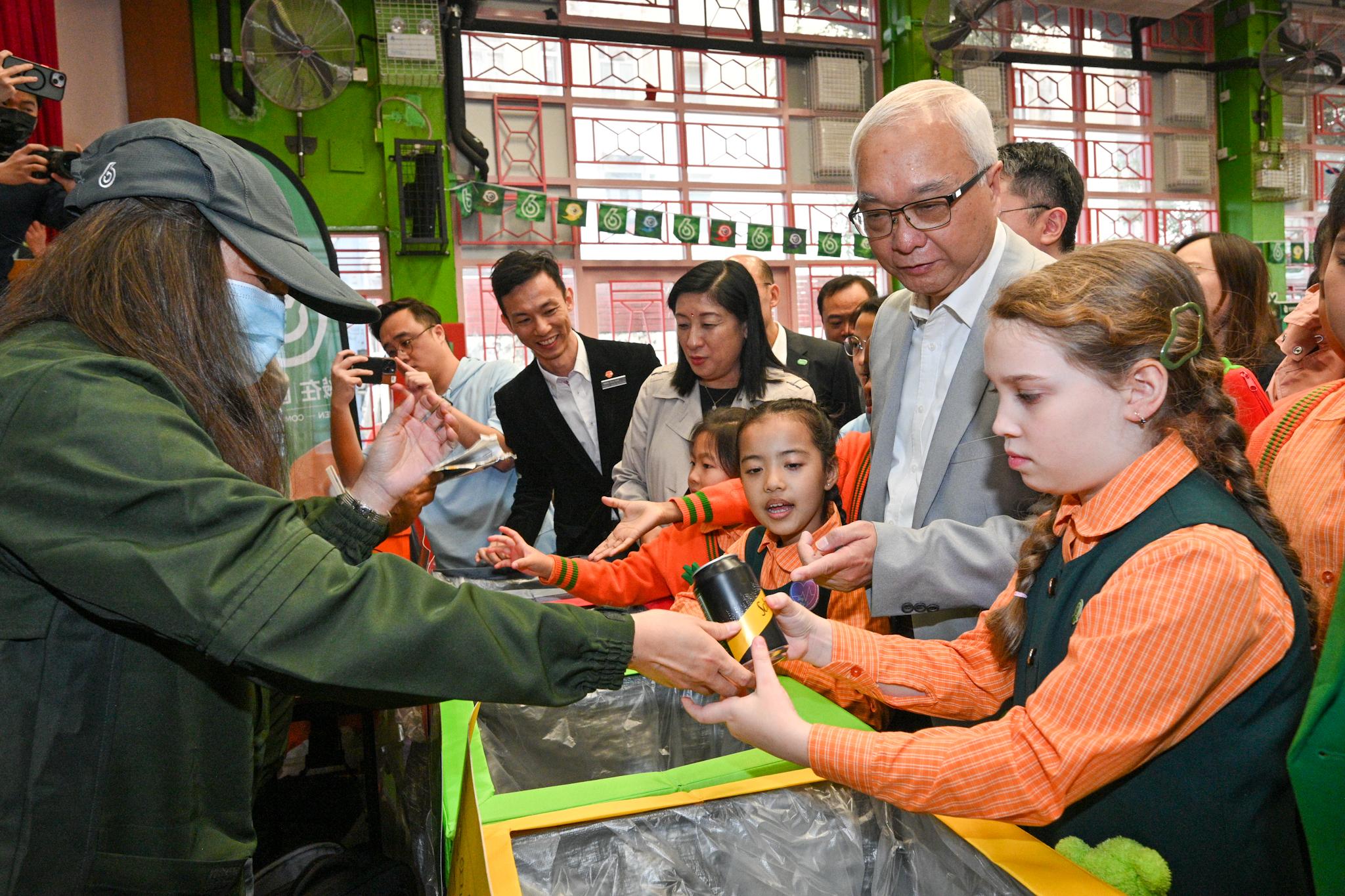 The Secretary for Environment and Ecology, Mr Tse Chin-wan, and the Under Secretary for Education, Mr Sze Chun-fai, today (January 16) visited Yaumati Kaifong Association School to promote municipal solid waste (MSW) charging to students. Photo shows Mr Tse (second right) participating in a quiz game on MSW charging together with school students.