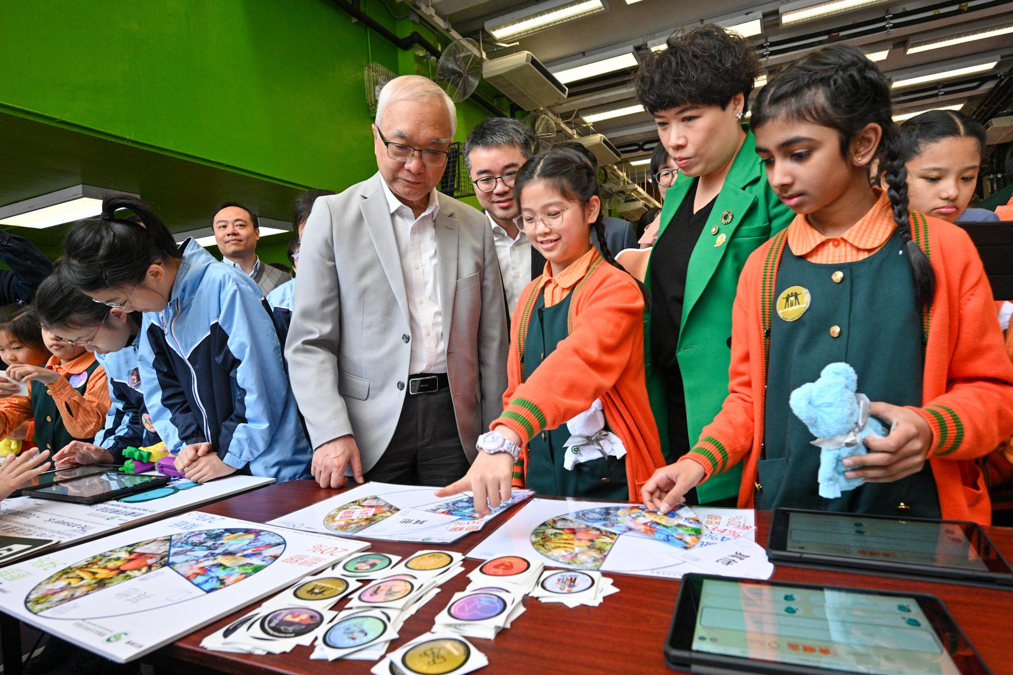 The Secretary for Environment and Ecology, Mr Tse Chin-wan, and the Under Secretary for Education, Mr Sze Chun-fai, today (January 16) visited Yaumati Kaifong Association School to promote municipal solid waste (MSW) charging to students. Photo shows Mr Tse (fifth right) and Mr Sze (fourth right) participating in a quiz game on MSW charging together with school students.