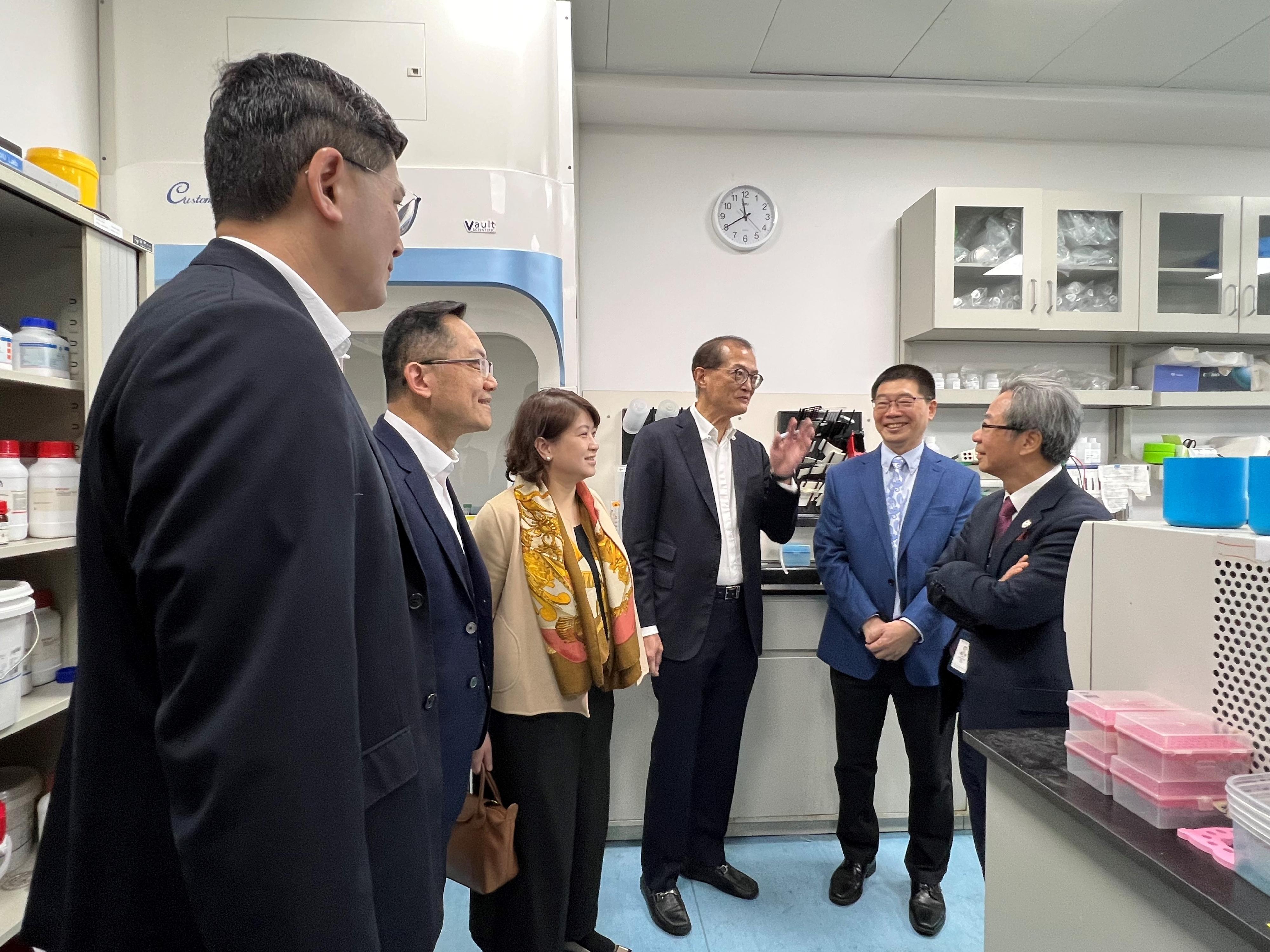 Accompanied by the Under Secretary for Health, Dr Libby Lee (third left); the Director of Health, Dr Ronald Lam (second left); and the Chief Executive of the Hospital Authority, Dr Tony Ko (first left), the Secretary for Health, Professor Lo Chung-mau (third right), visits a laboratory at the School of Medicine of the Chinese University of Hong Kong, Shenzhen, and chats with the Founding Dean of the School of Medicine, Professor Davy Cheng (first right), today (January 19).
