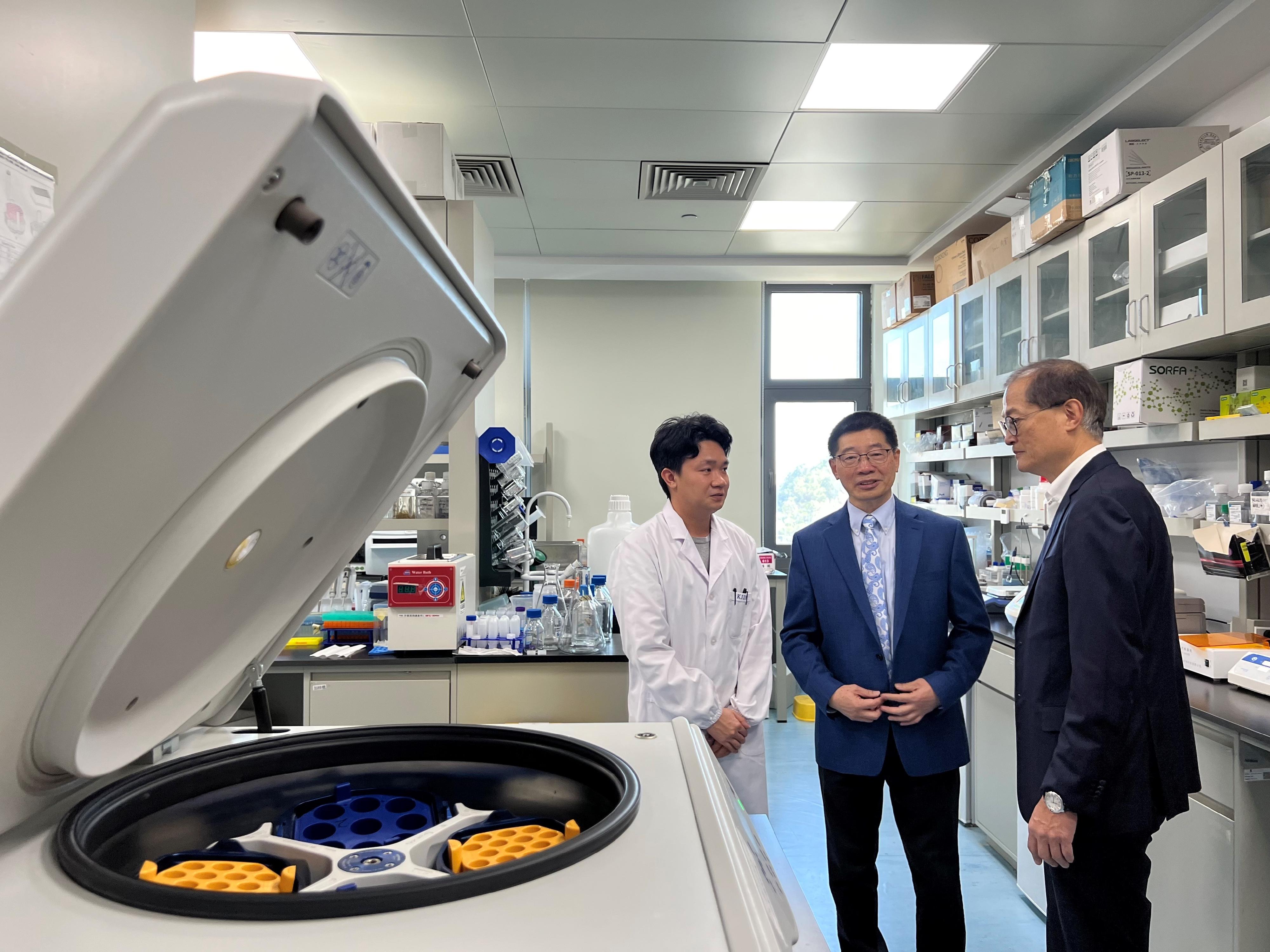The Secretary for Health, Professor Lo Chung-mau (right), visits a laboratory at the School of Medicine of the Chinese University of Hong Kong, Shenzhen, in the company of staff members of the School today (January 19).