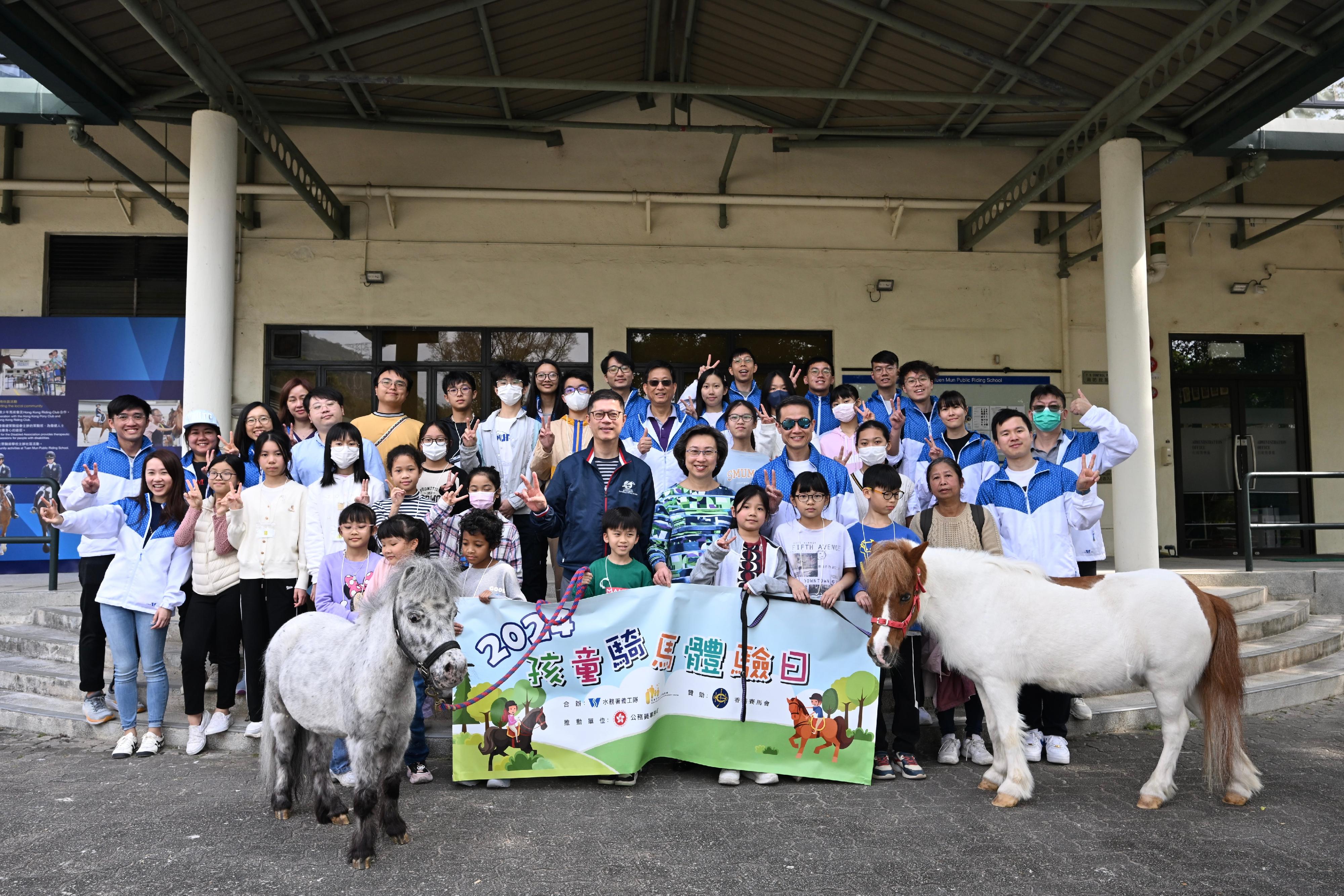About 20 children from grassroots families today (January 20) visited the Tuen Mun Public Riding School in the company of civil service volunteers to sample the fun of horse riding and learn about the environment of horses at the stables. The Secretary for the Civil Service, Mrs Ingrid Yeung (second row, fifth right); the Director of Water Supplies, Mr Tony Yau (second row, fourth right); the Head of External Affairs of the Hong Kong Jockey Club, Mr Freely Cheng (second row, sixth right), are pictured with the civil service volunteers and the participating children.