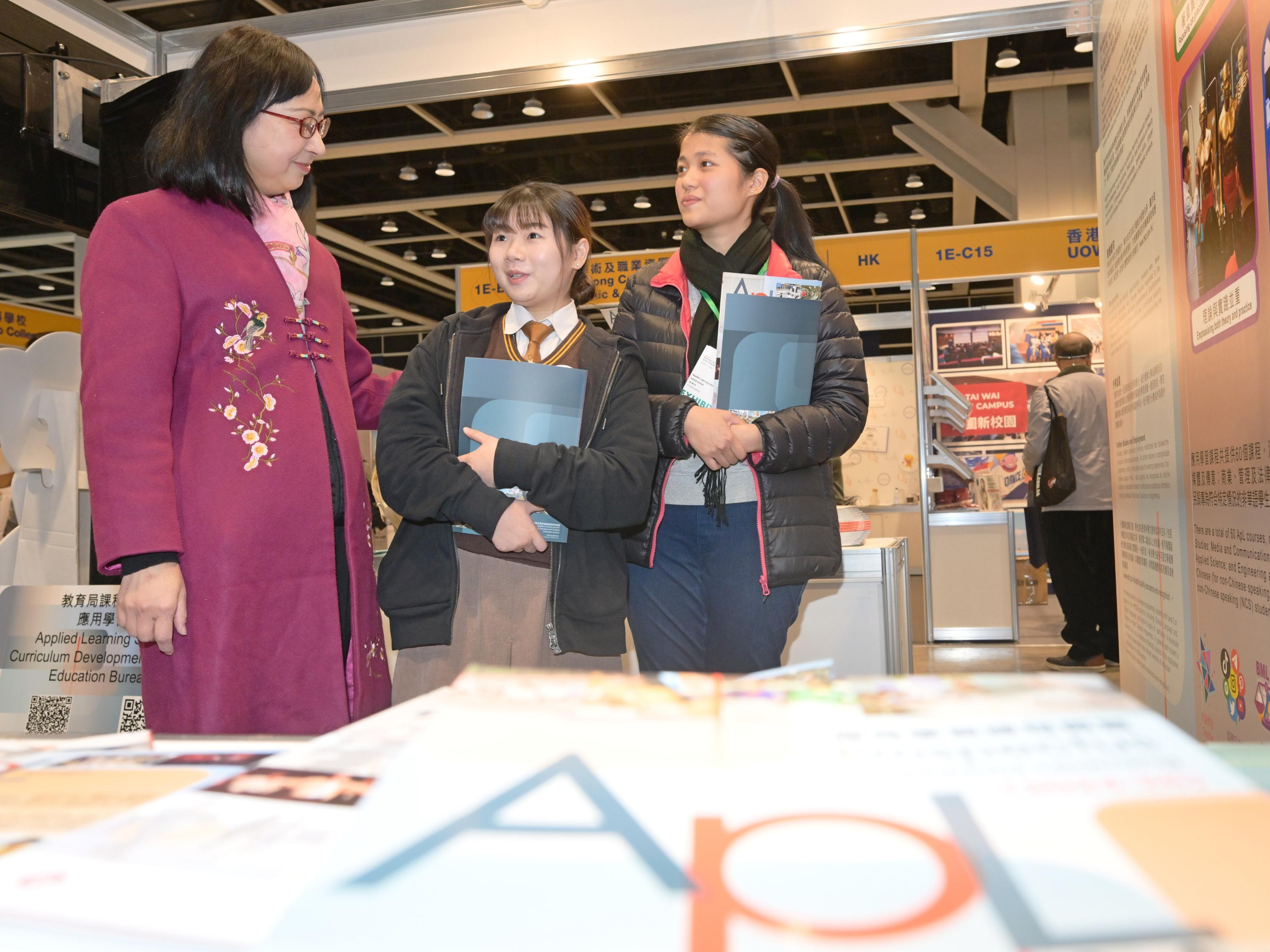 The Permanent Secretary for Education, Ms Michelle Li (first left), is briefed by student ambassadors, who are Applied Learning scholarship awardees, on the promotion of Applied Learning at the Education & Careers Expo 2024 today (January 25).