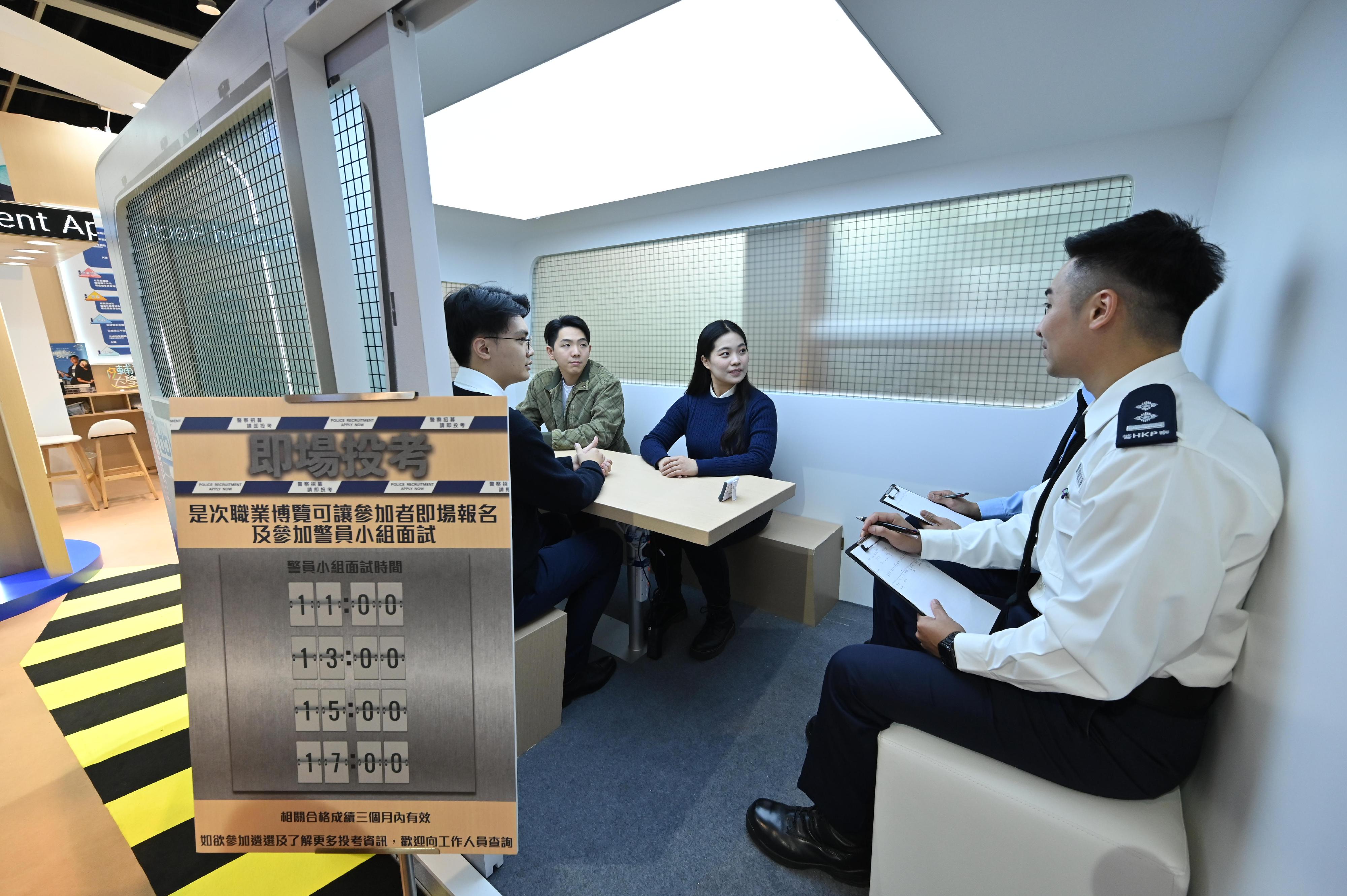 The Hong Kong Police Force introduces its work and provides recruitment information to visitors at the Education and Careers Expo 2024 for four consecutive days from today (January 25). Photo shows visitors attending an on-site group interview session for Police Constable on the "Recruitment Emergency Unit Car" set up at the booth.