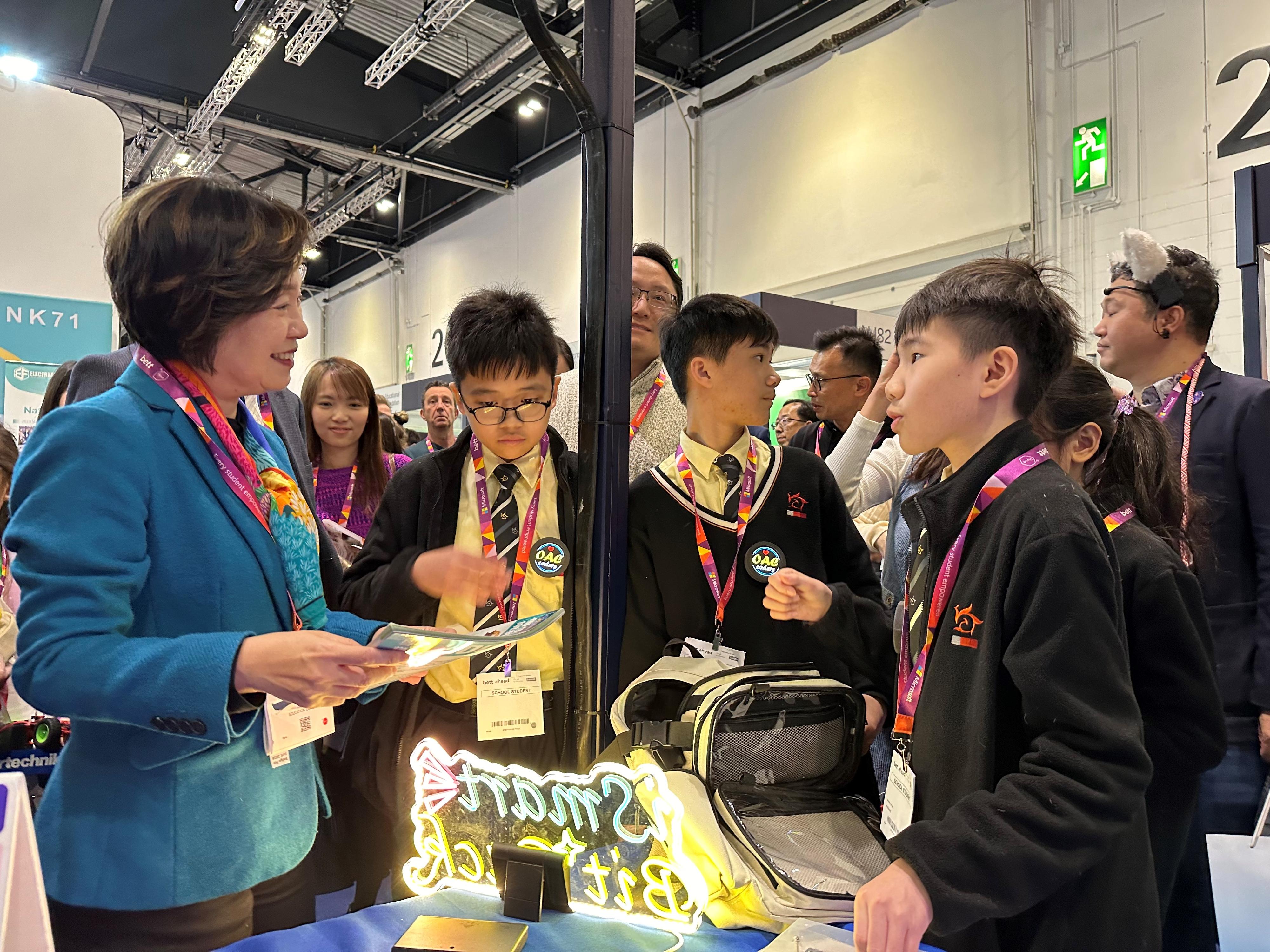 The Secretary for Education, Dr Choi Yuk-lin, toured the British Educational Training and Technology Show by invitation in London, the United Kingdom, on January 25 (London time). Photo shows Dr Choi (first left) chatting with a Hong Kong student participating in the show.
