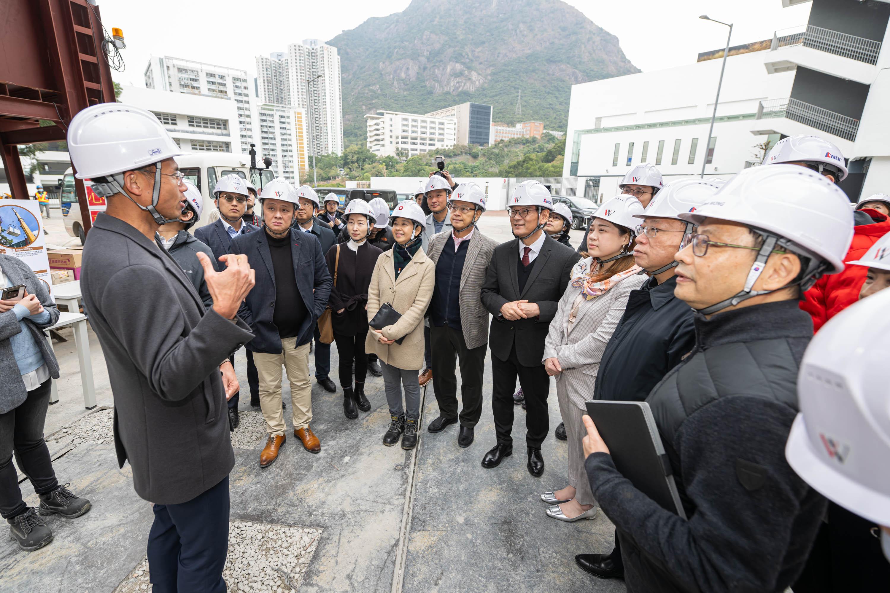 The Legislative Council (LegCo) Public Works Subcommittee visited the Choi Hing Road transitional housing project in Ngau Tau Kok today (January 29). Photo shows LegCo Members receiving a briefing on the Choi Hing Road project. 
