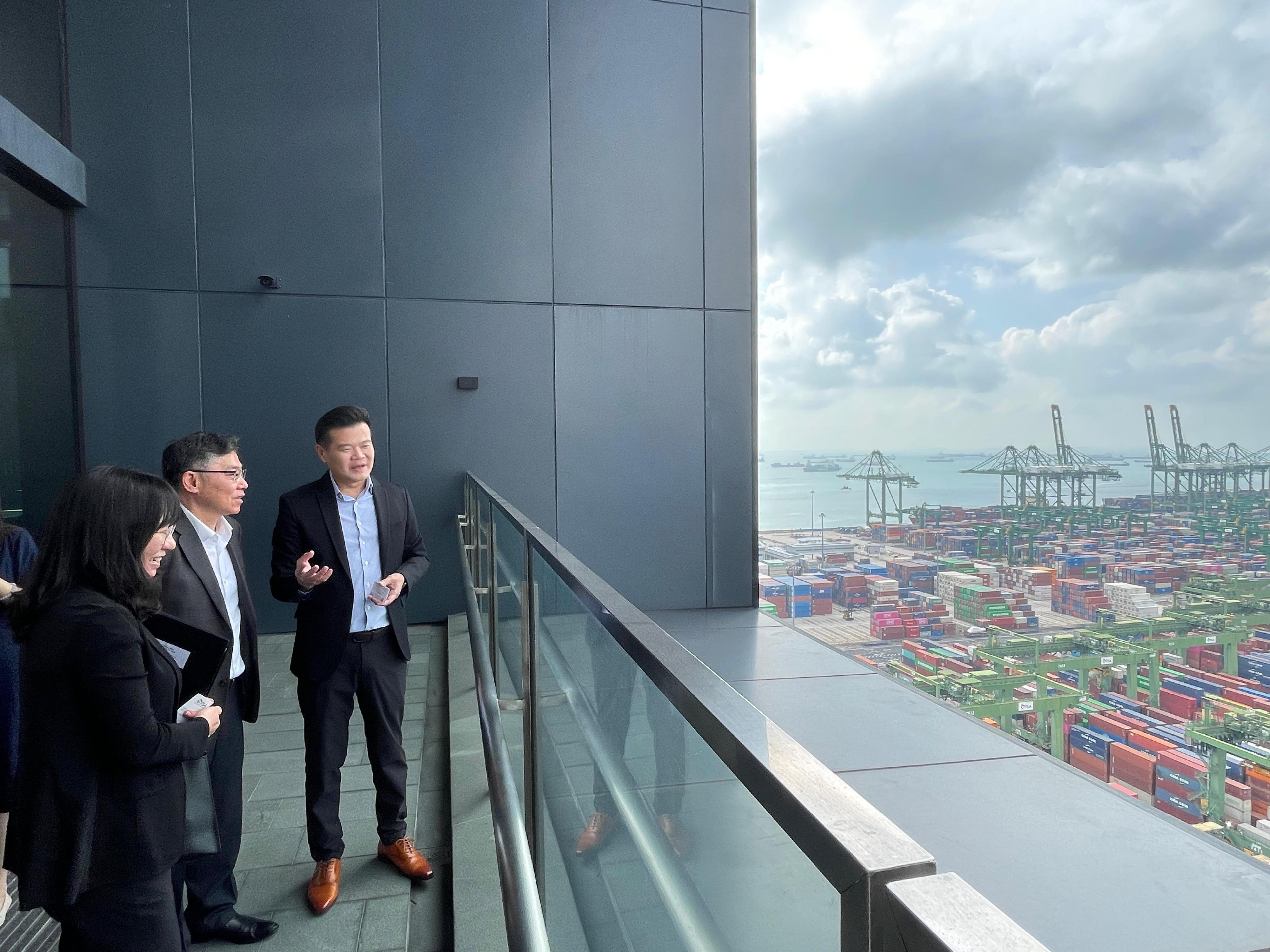 The Secretary for Transport and Logistics, Mr Lam Sai-hung (centre), began his visit programme to Singapore today (January 30). Photo shows Mr Lam, accompanied by the Commissioner for Maritime and Port Development and Deputy Secretary for Transport and Logistics, Miss Amy Chan (left), visiting the port in Singapore where he had a bird's eye view of the Pasir Panjang Terminals.