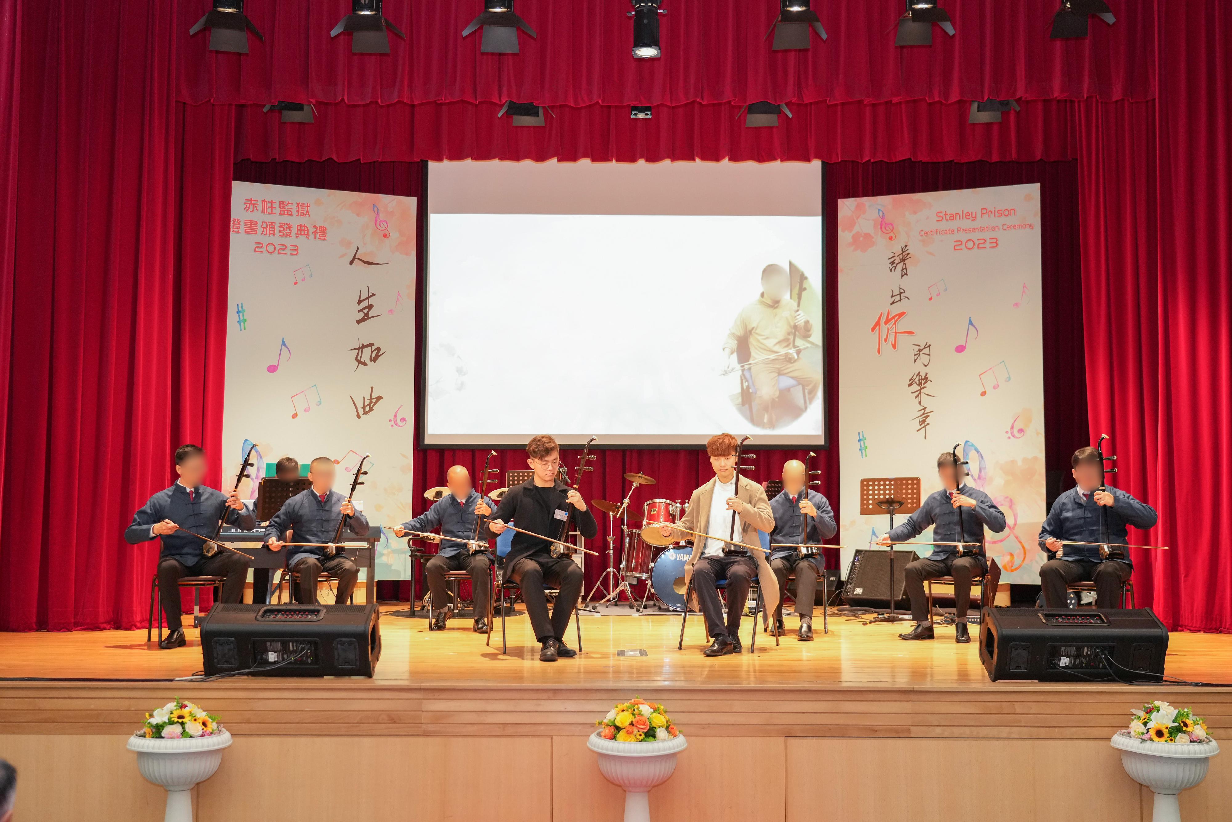 在囚人士與義工導師二胡演奏家朱芸編（右四）及香港青少年國樂團成員江建彬（左四）表演二胡。