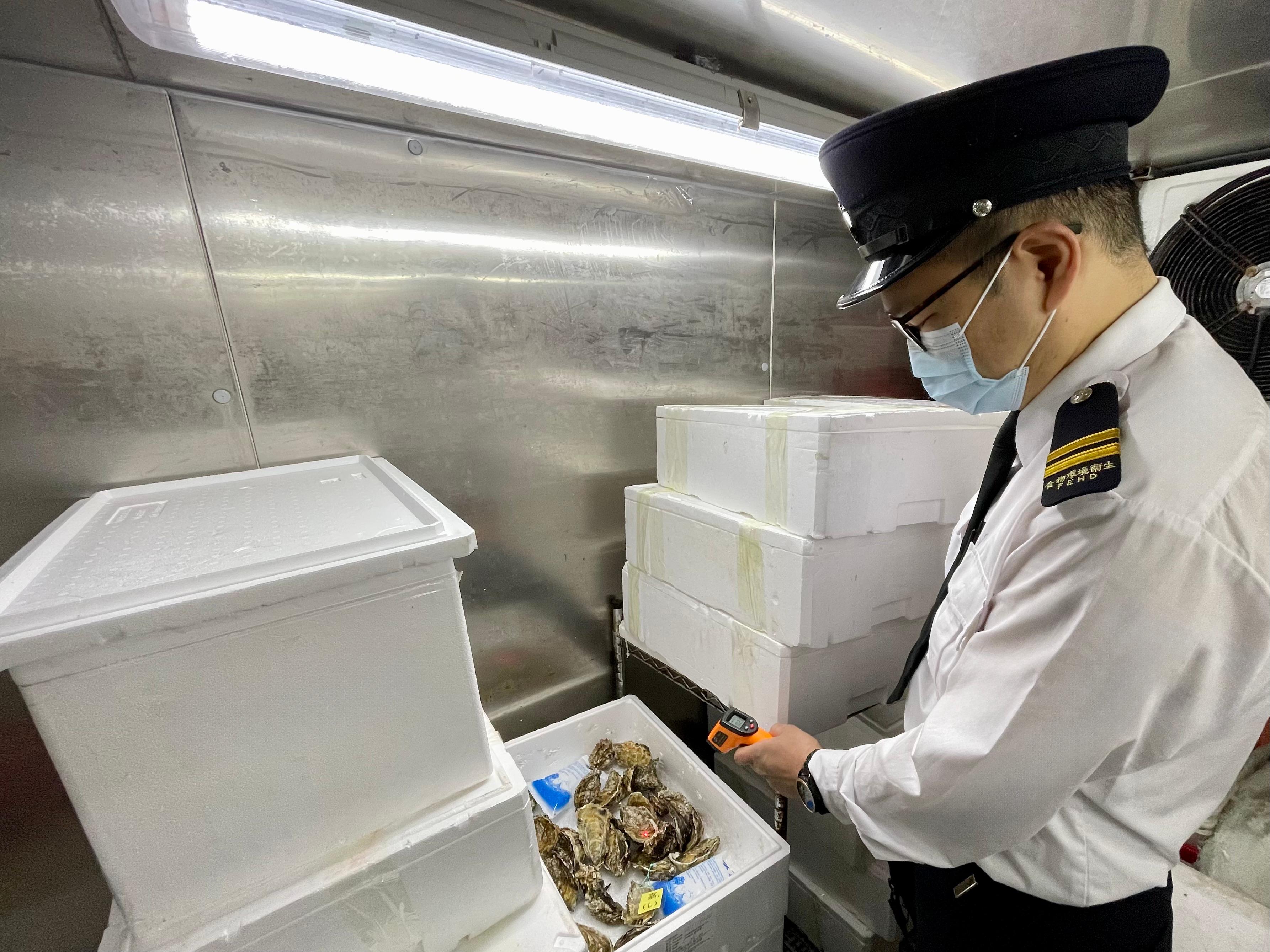 To safeguard food safety and protect public health, the Centre for Food Safety and the Environmental Hygiene Branch of the Food and Environmental Hygiene Department (FEHD) have enhanced inspections before the Lunar New Year holidays of various licensed food premises across the territory to ensure that oysters to be eaten in a raw state (raw oysters) be stored at the proper temperature. Photo shows an FEHD officer inspecting the storing temperature of raw oysters.