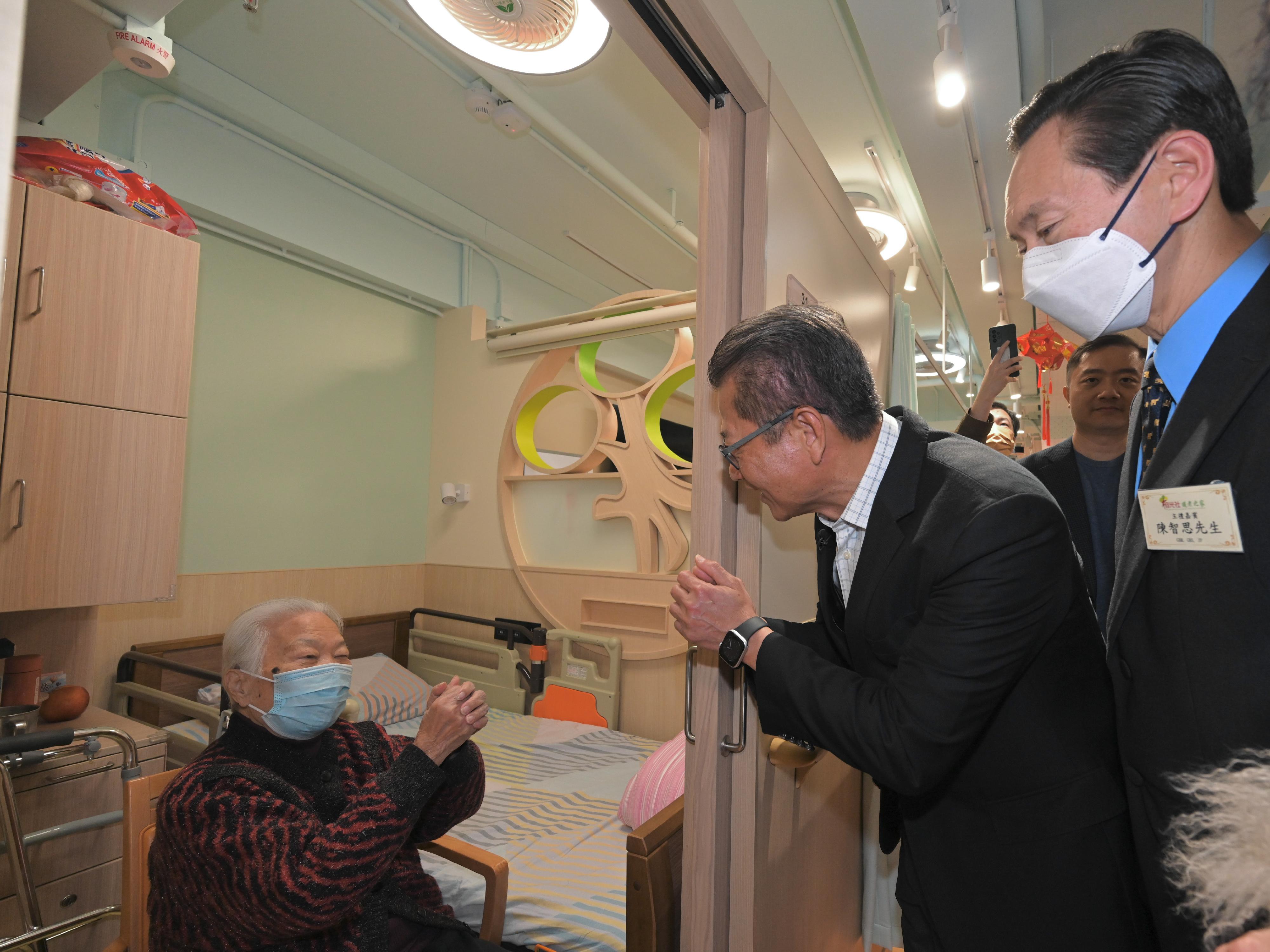 财政司司长陈茂波今日（二月三日）出席榕光社护老之家开幕礼。图示陈茂波（中）参观院舍设施，并与长者交谈。