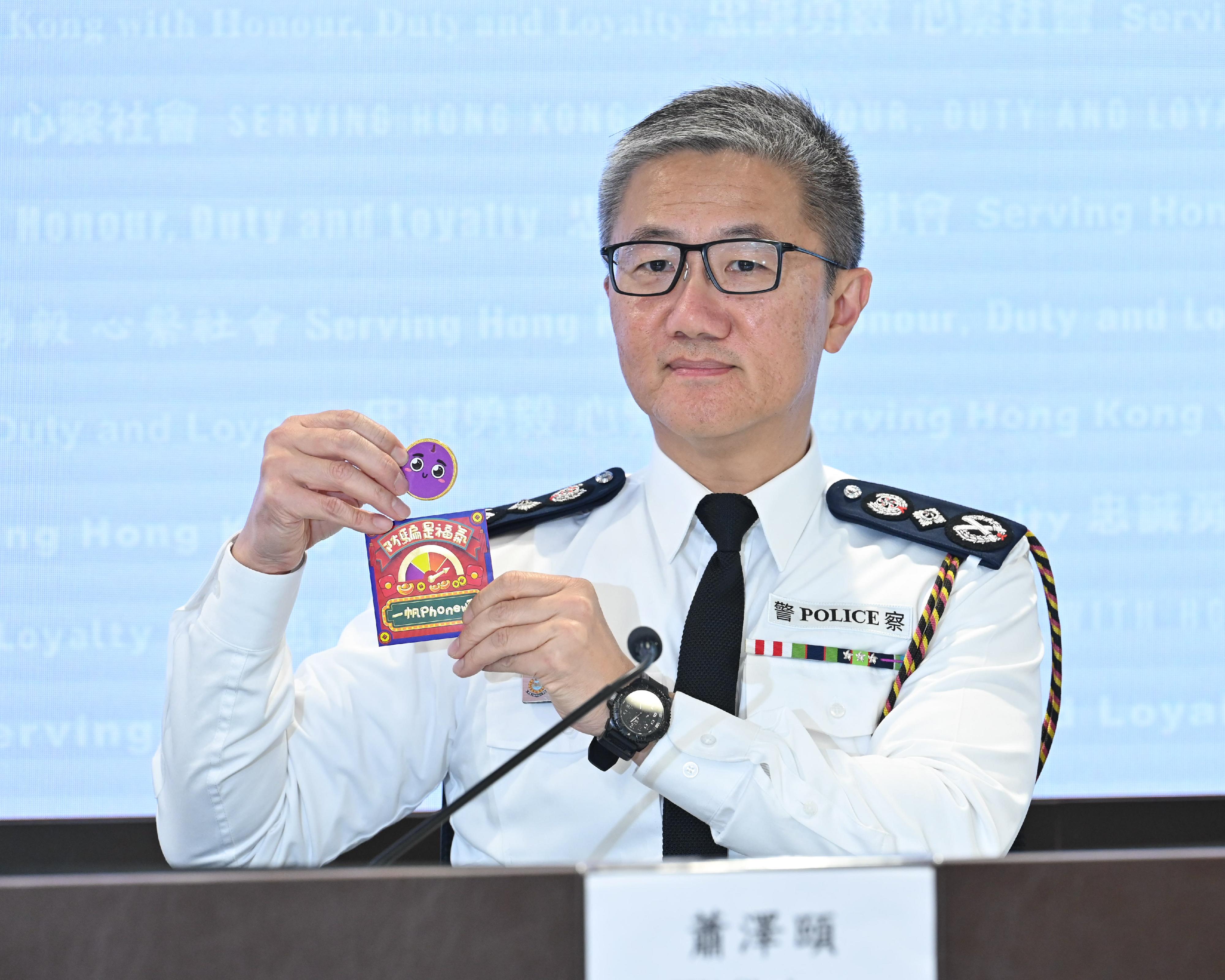 警務處處長蕭澤頤今日（二月六日）在記者會上回顧2023年香港的治安情況及警務工作。圖示蕭澤頤在記者會上展示送給傳媒的防騙宣傳品「提子壓歲錢」。