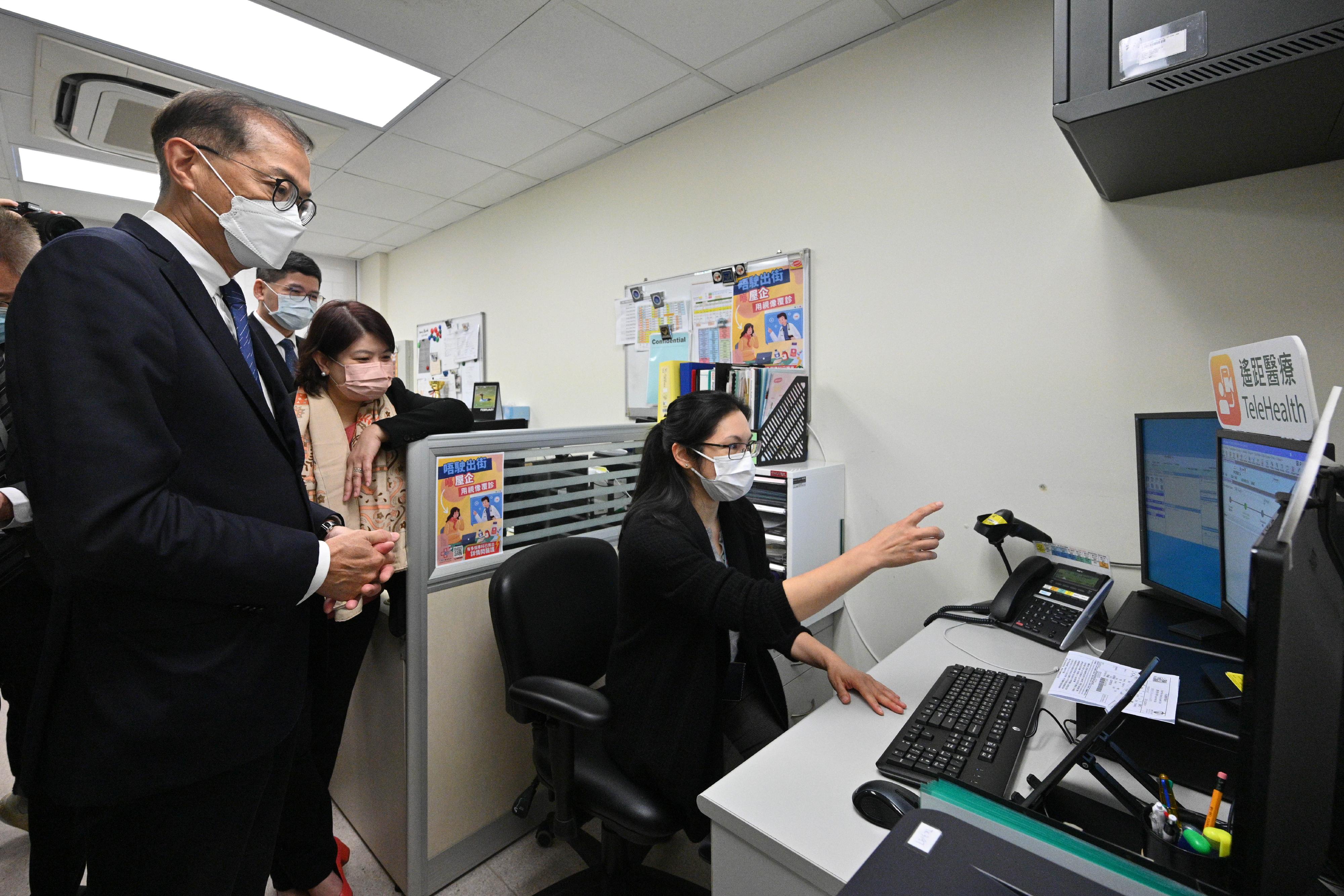 The Secretary for Health, Professor Lo Chung-mau (first left), and the Under Secretary for Health, Dr Libby Lee (second right), inspect Robert Black General Out-patient Clinic this morning (February 6), and receive an introduction by the healthcare personnel on tele-consultation service.