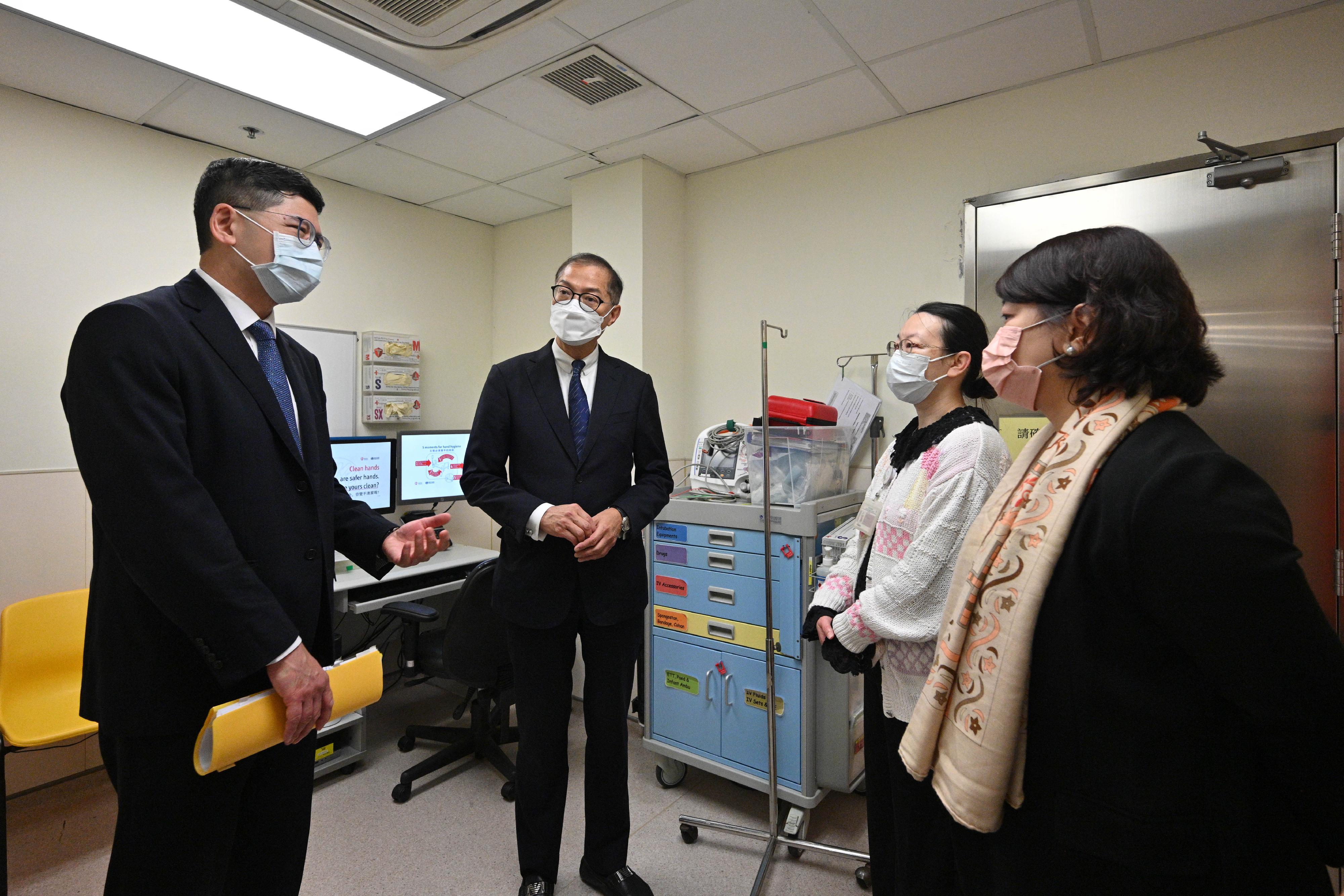 Accompanied by the Chief Executive of the Hospital Authority, Dr Tony Ko (first left), the Secretary for Health, Professor Lo Chung-mau (second left), and the Under Secretary for Health, Dr Libby Lee (first right), interact with healthcare personnel at Robert Black General Out-patient Clinic this morning (February 6).
