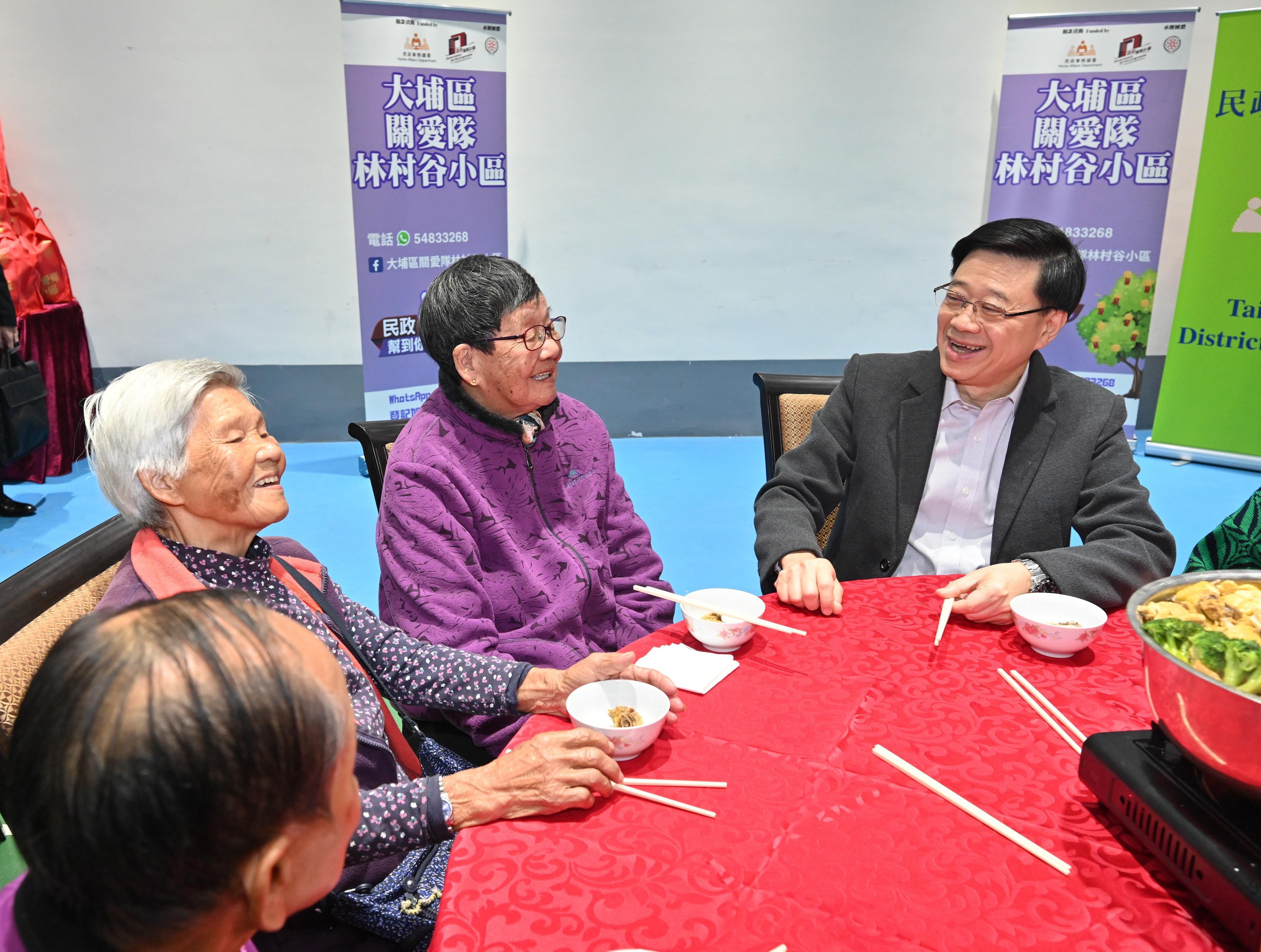 行政長官李家超今日（二月七日）到訪大埔區。圖示李家超（右一）與長者在享用盆菜前交談。