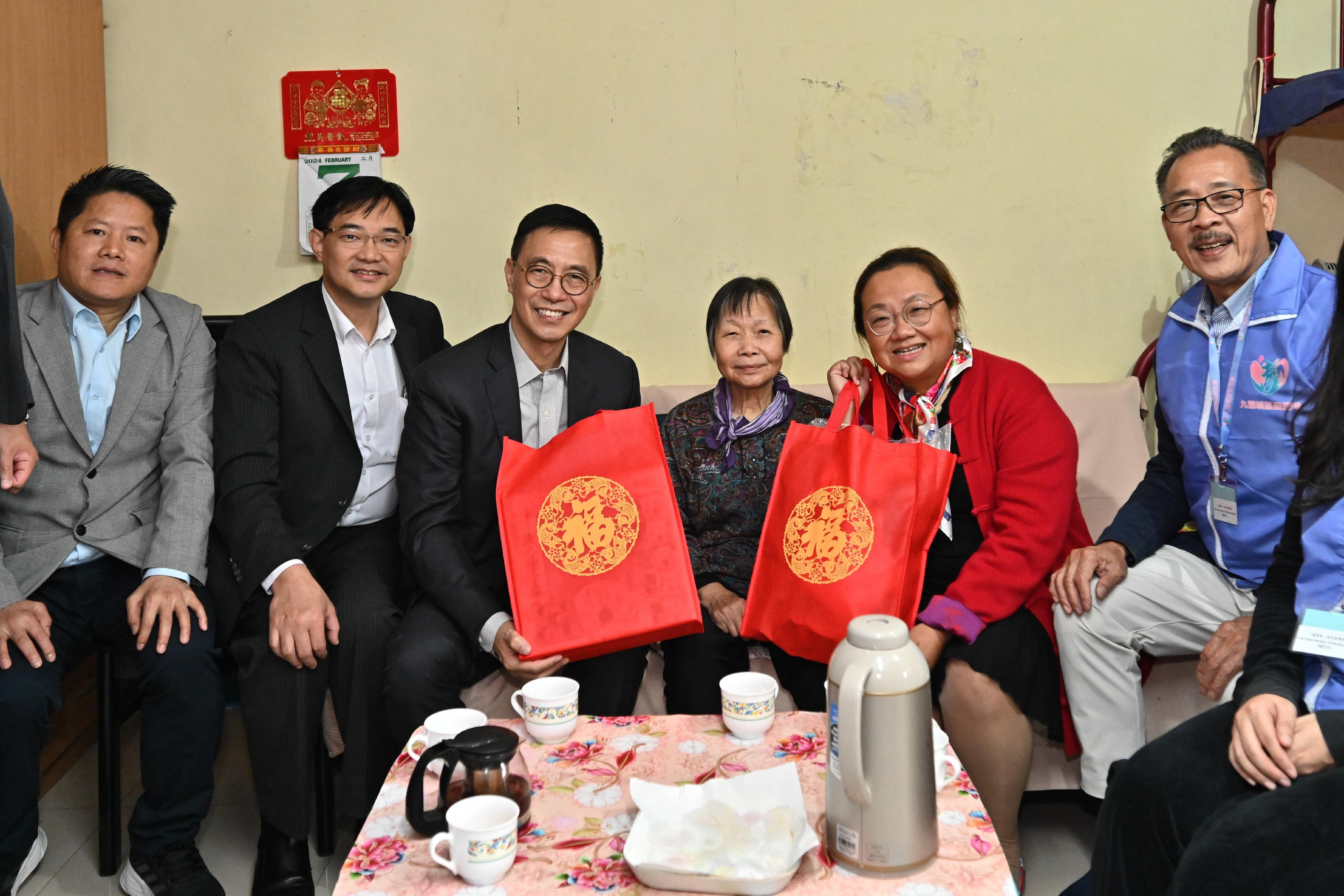 文化体育及旅游局局长杨润雄（左三）今日（二月七日）在九龙城民政事务专员蔡敏君（右二）陪同下，探访居于何文田爱民邨的独居长者和双老家庭。