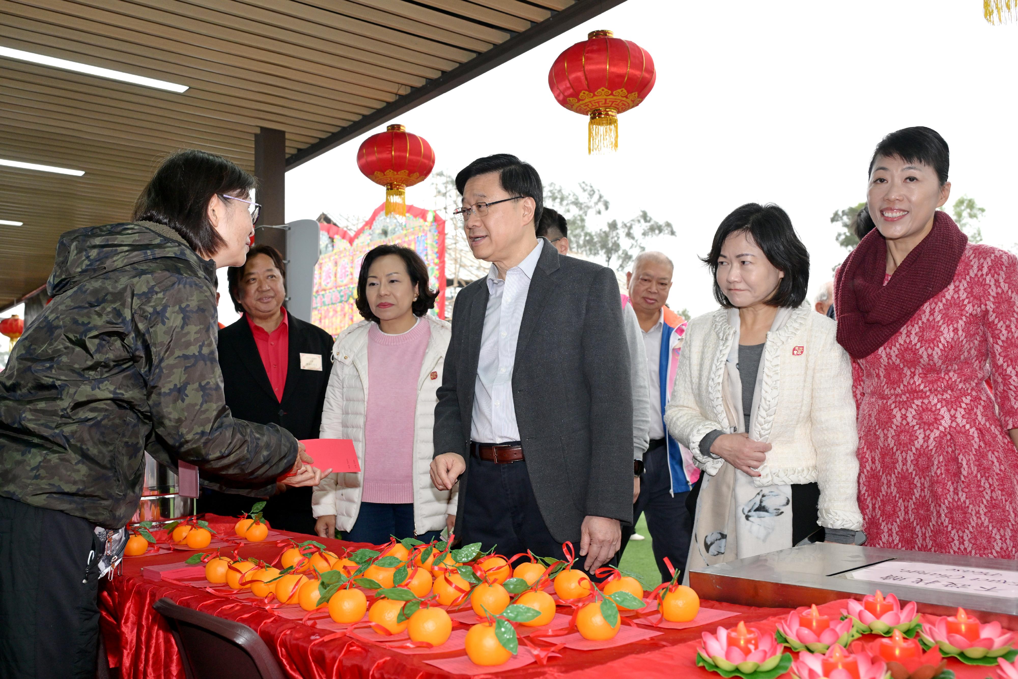 The Chief Executive, Mr John Lee, visited Tai Po today (February 7). Photo shows Mr Lee (front row, third right), chatting with a stall operator. Looking on are the Secretary for Home and Youth Affairs, Miss Alice Mak (front row, fourth right); the Director of Home Affairs, Mrs Alice Cheung (front row, second right); and the District Officer (Tai Po), Ms Eunice Chan (front row, first right).
