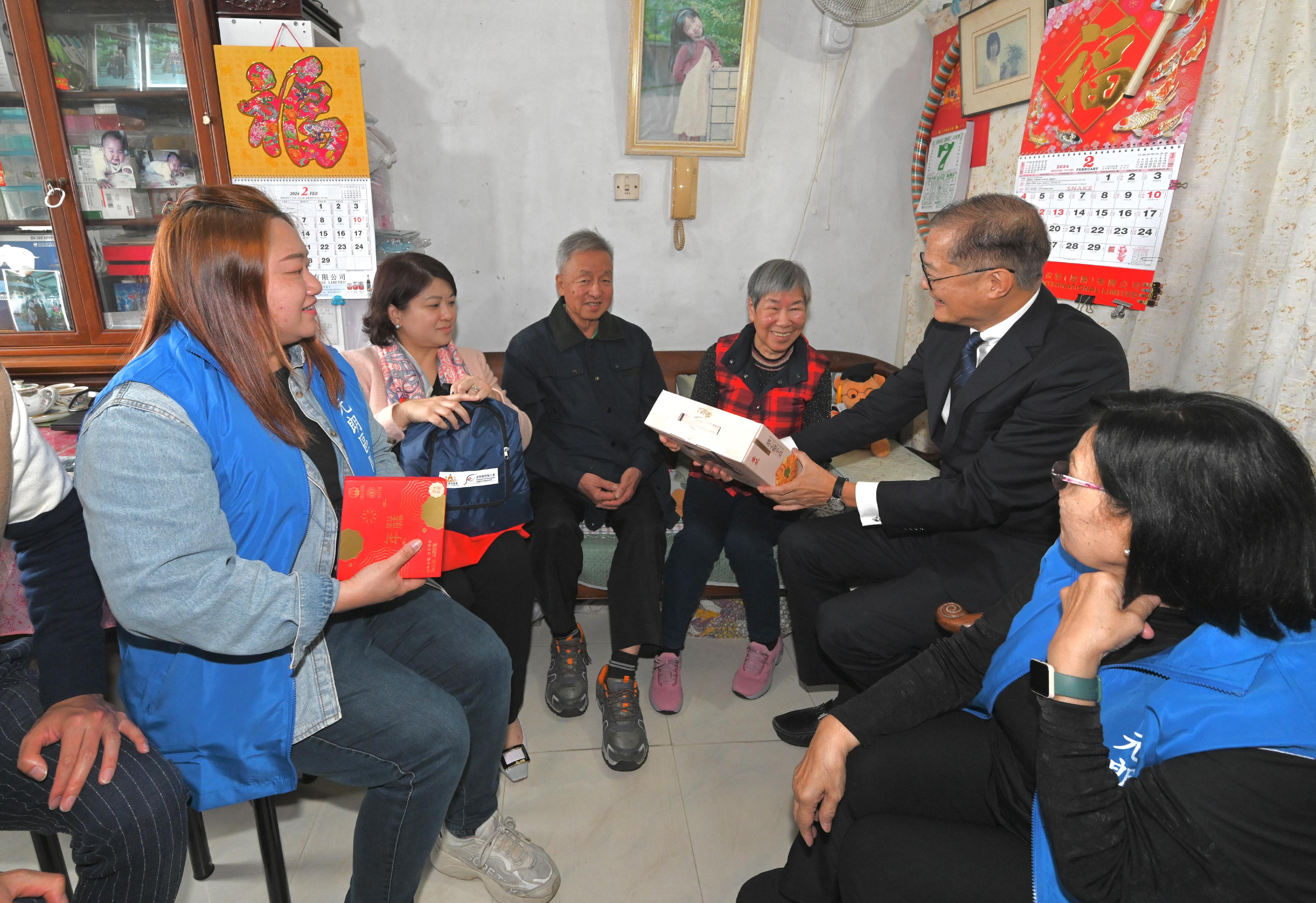 The Secretary for Health, Professor Lo Chung-mau (second right), and the Under Secretary for Health, Dr Libby Lee (second left), together with Yuen Long District Council members and representatives from the Care Team (Yuen Long) visit a grassroots family living in Tin Wah Estate in Tin Shui Wai today (February 7) to present gifts and extend seasonal greetings to them on behalf of the Government.