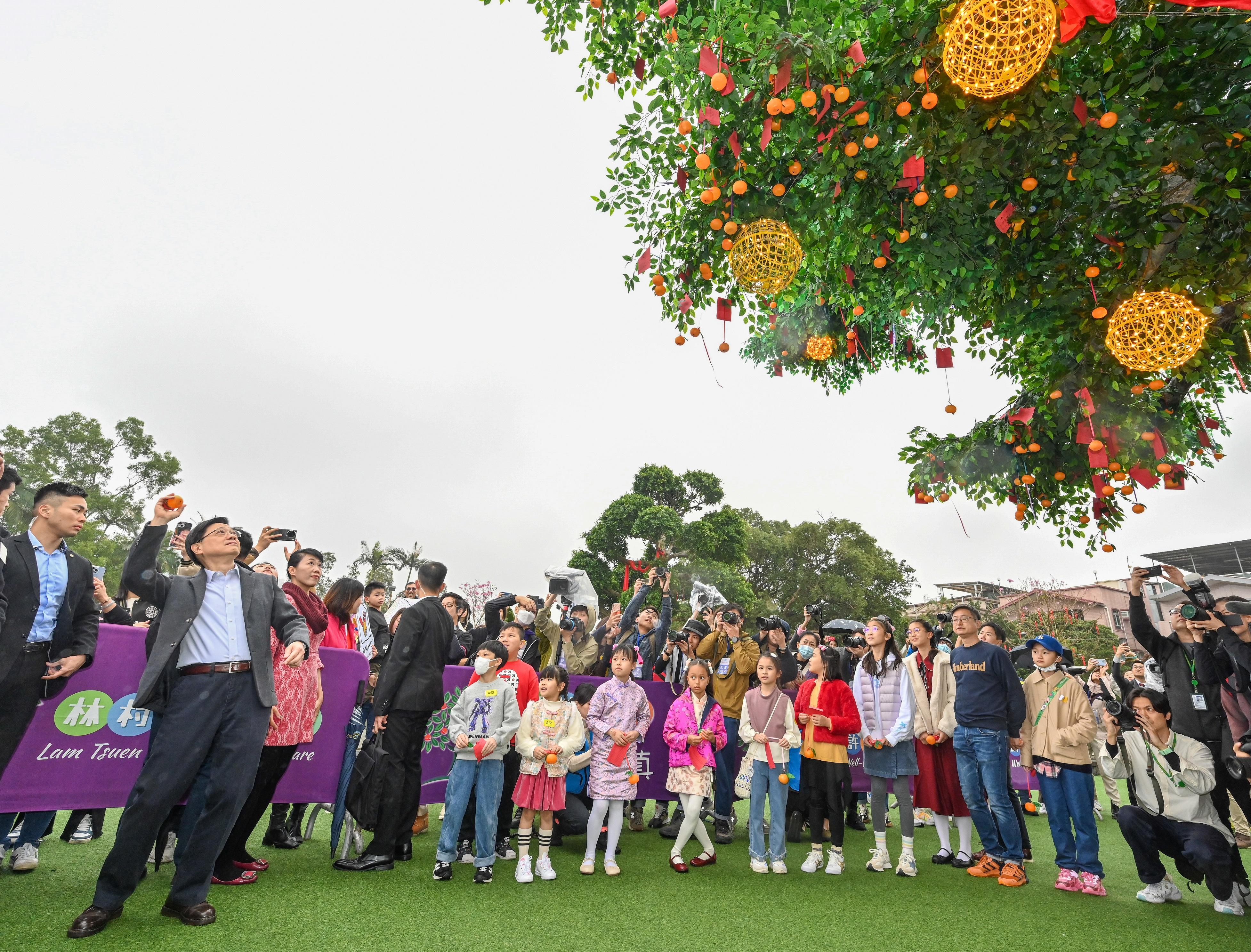 The Chief Executive, Mr John Lee, visited Tai Po today (February 7). Photo shows Mr Lee (second left) throwing a wishing placard onto the Wishing Tree at Lam Tsuen to make wishes. 
