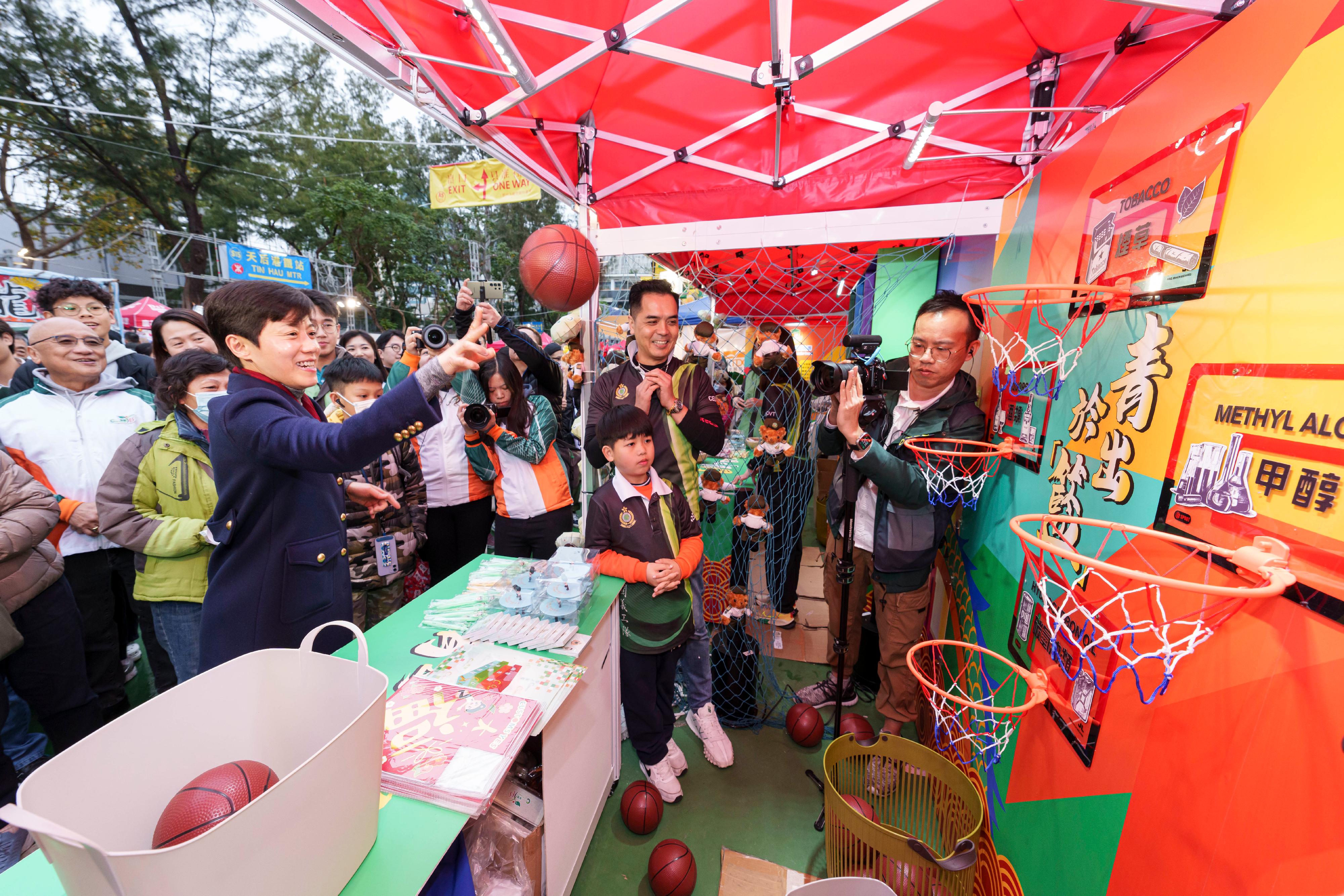 海关关长何佩珊（左一）今日（二月八日）参观「海关缤FUN庆龙年」新春年宵摊位，参与摊位游戏。