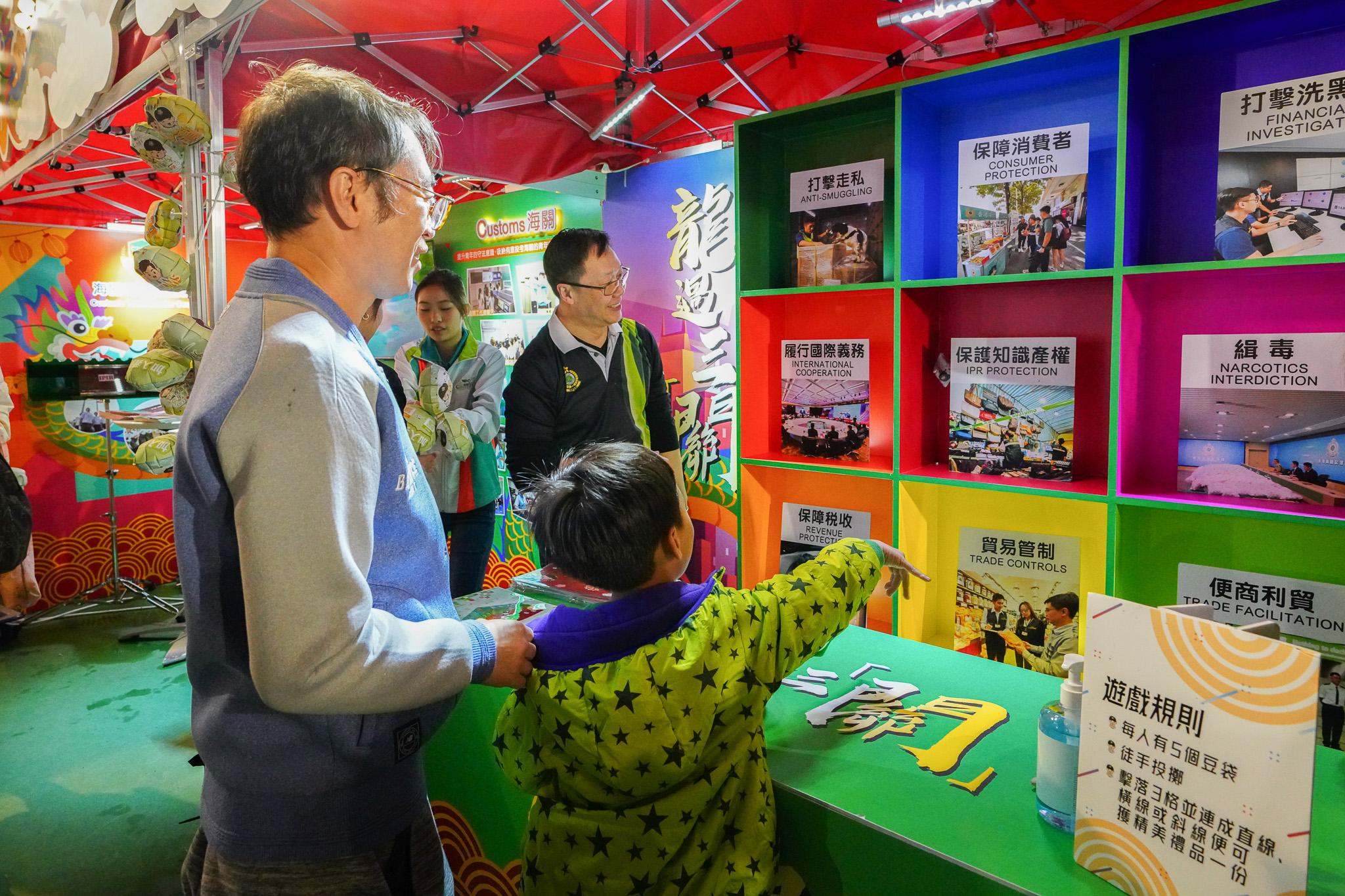 香港海关在二月七日至九日于维多利亚公园年宵市场摆设「海关缤FUN庆龙年」为题的新春年宵摊位，并与社福机构「生命热线」携手举办年宵慈善义卖。图示到场参观和参与摊位游戏的市民。