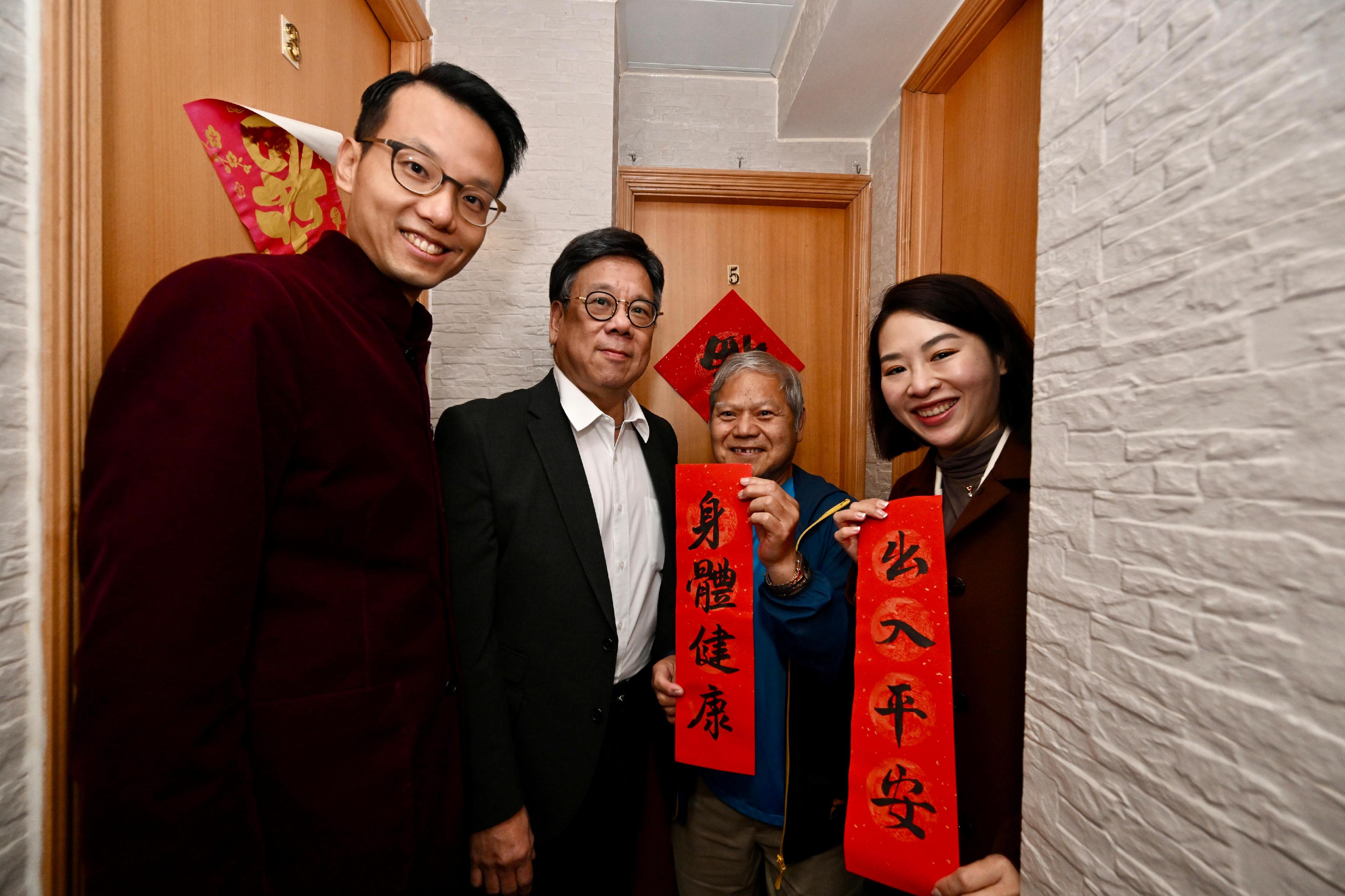 The Secretary for Commerce and Economic Development, Mr Algernon Yau (second left), accompanied by the District Officer (Kwai Tsing), Mr Huggin Tang (first left), and Kwai Tsing District Council member Ms Jody Kwok (first right) visit an elderly person living at Shek Lei, Kwai Chung, today (February 8).