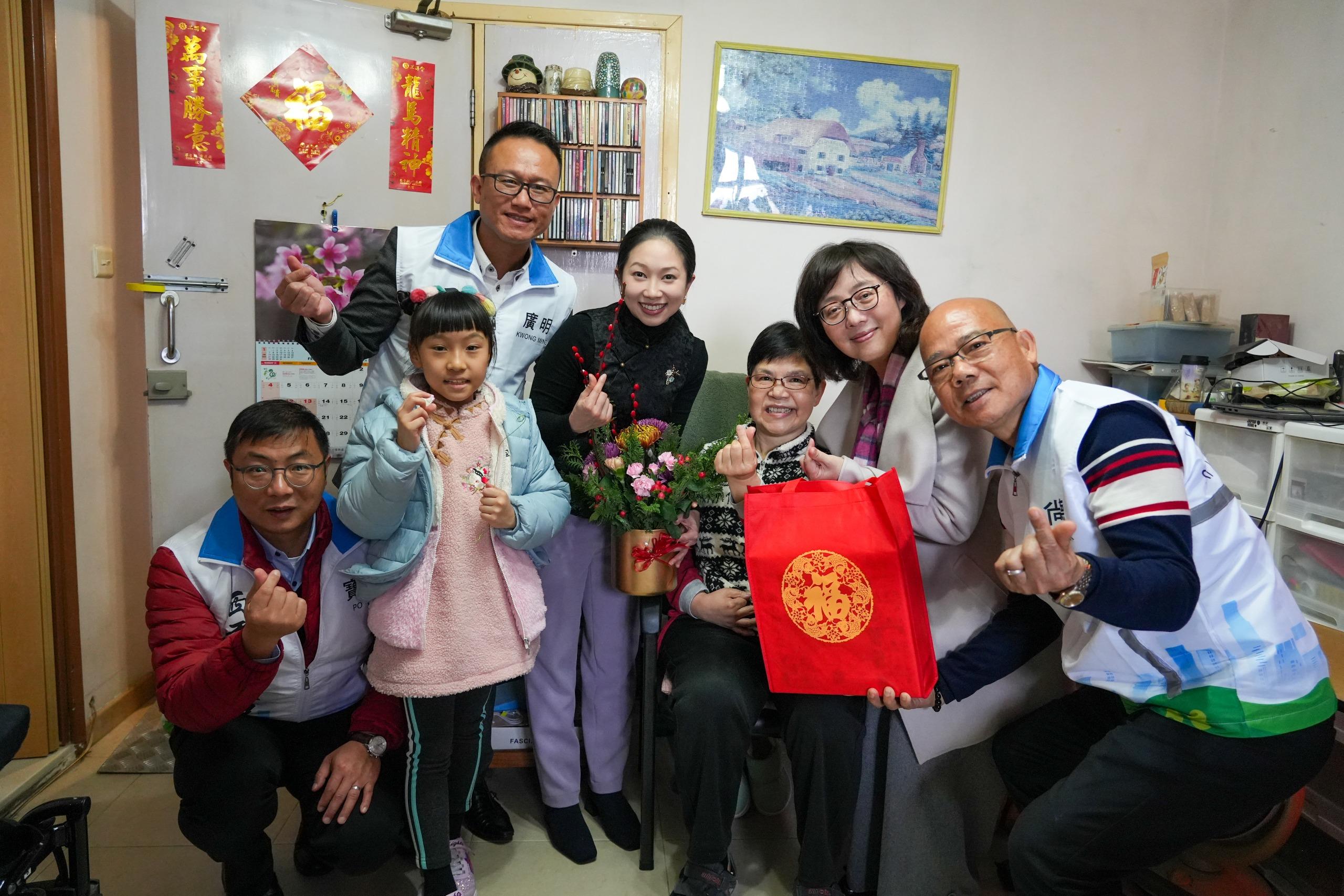 The Secretary for Development, Ms Bernadette Linn (second right), accompanied by the District Officer (Sai Kung), Miss Kathy Ma (centre), and Sai Kung District Council members and representatives from the Care Team (Sai Kung), today (February 8) visited and extended festive greetings to households at Sheung Tak Estate, Tseung Kwan O. Photo shows Ms Linn presenting a Chinese New Year blessing bag and a floral decoration to an elderly person.