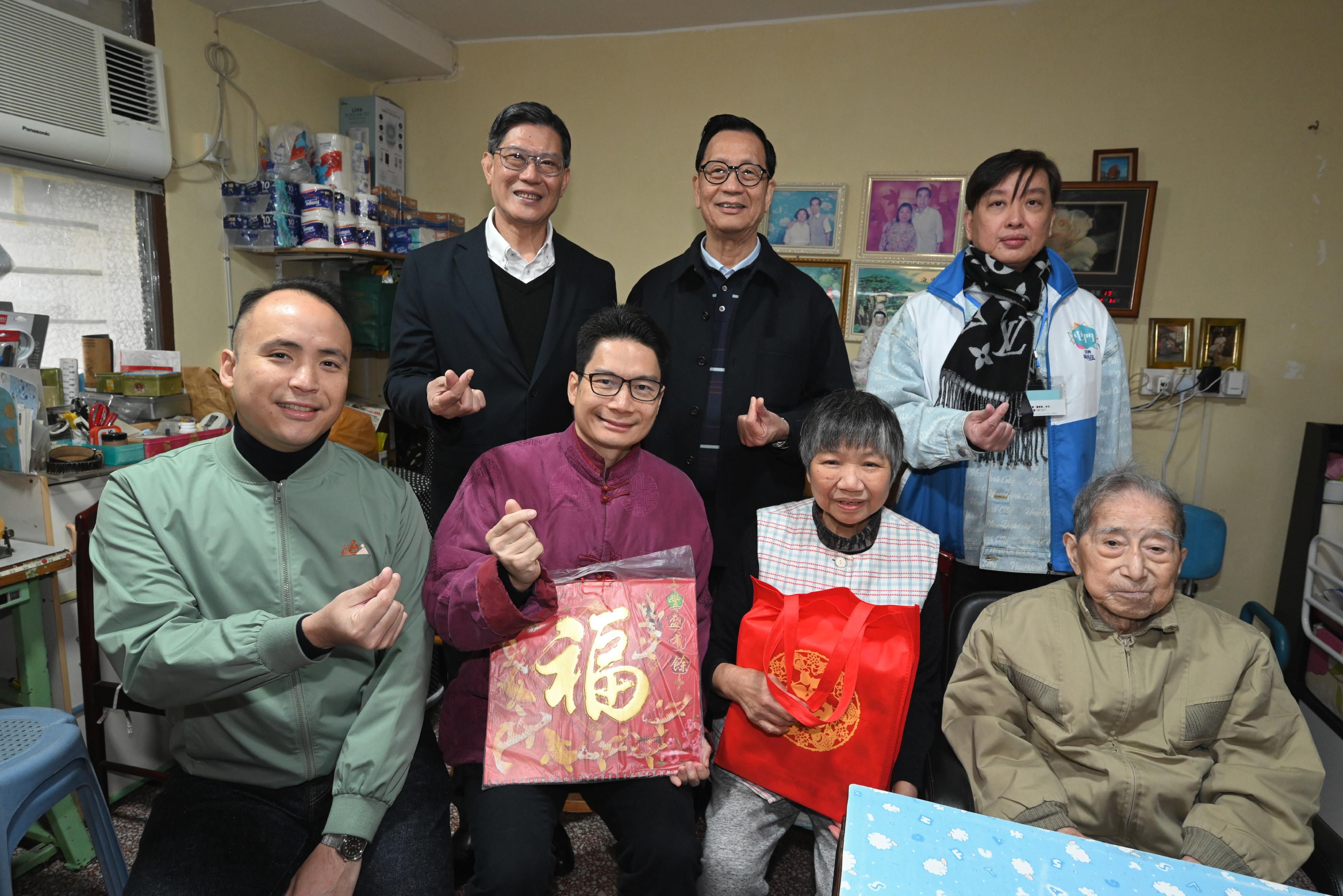 The Acting Secretary for Financial Services and the Treasury, Mr Joseph Chan, today (February 9) visited elderly couples and singletons living in Tai Hing Estate, Tuen Mun, and distributed blessing bags in celebration of the Chinese New Year. Photo shows Mr Chan (front row, second left), together with the District Officer (Tuen Mun), Mr Michael Kwan (front row, first left), Tuen Mun District Council members and representatives from the Care Team (Tuen Mun), visiting an elderly couple in Tai Hing Estate.