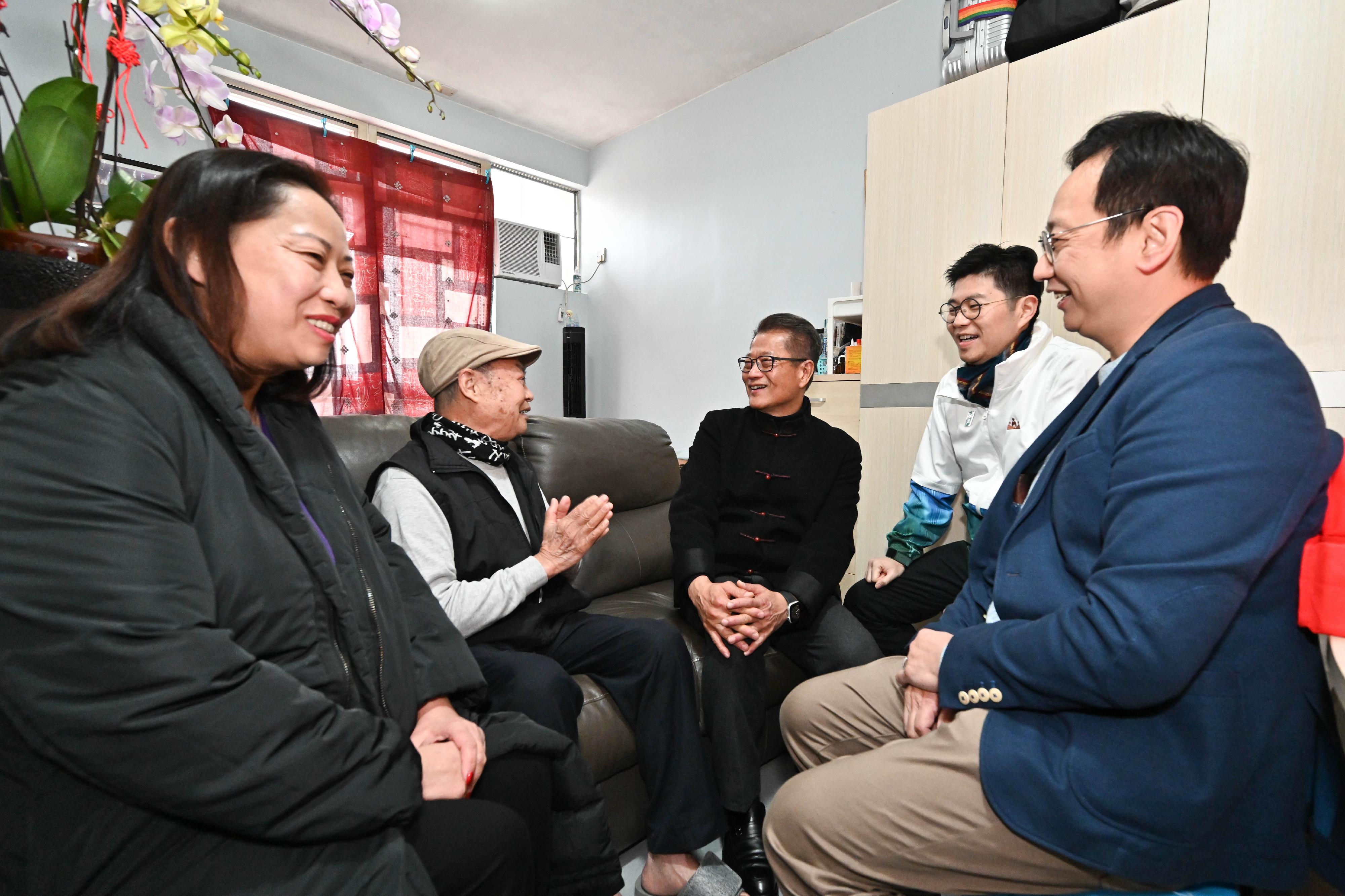 The Financial Secretary, Mr Paul Chan (centre), accompanied by the District Officer (Kwun Tong), Mr Denny Ho (second right), visits elderly people living in Tak Tin Estate, Lam Tin, today (February 9) to extend Chinese New Year blessings.