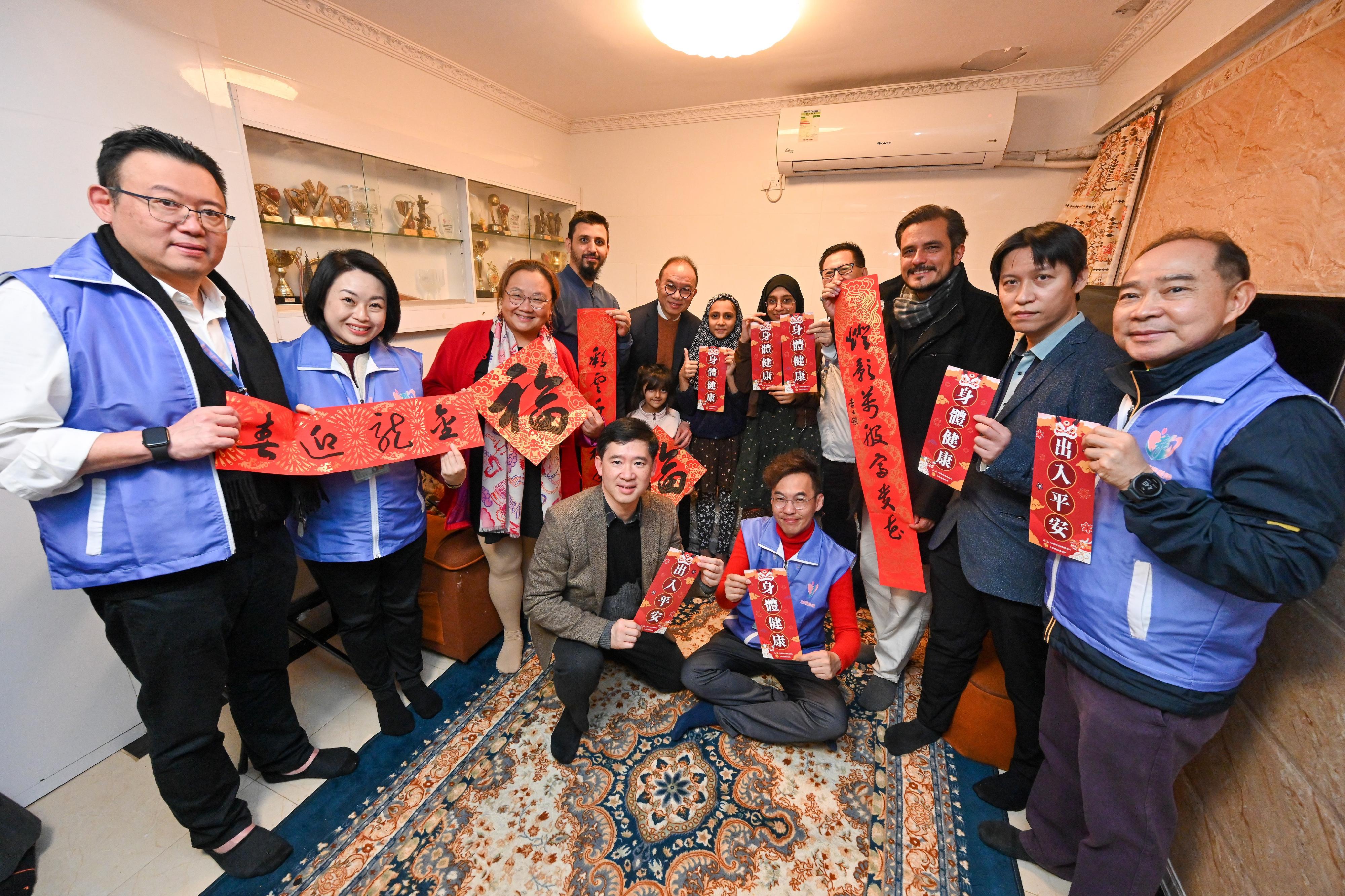 The Secretary for Constitutional and Mainland Affairs, Mr Erick Tsang Kwok-wai, and the Under Secretary Mr Clement Woo today (February 9) visited ethnic-minority families living in Kowloon City to learn about their daily lives and needs in Hong Kong and presented them with blessing bags on behalf of the Government to demonstrate care, and share with them the festive joy. Photo shows Mr Tsang (back row, fifth left) and Mr Woo (front row, first left) together with the District Officer (Kowloon City), Miss Alice Choi (back row, third left), Kowloon City District Council members and representatives from the Care Team (Kowloon City) giving New Year blessings to an ethnic-minority family.