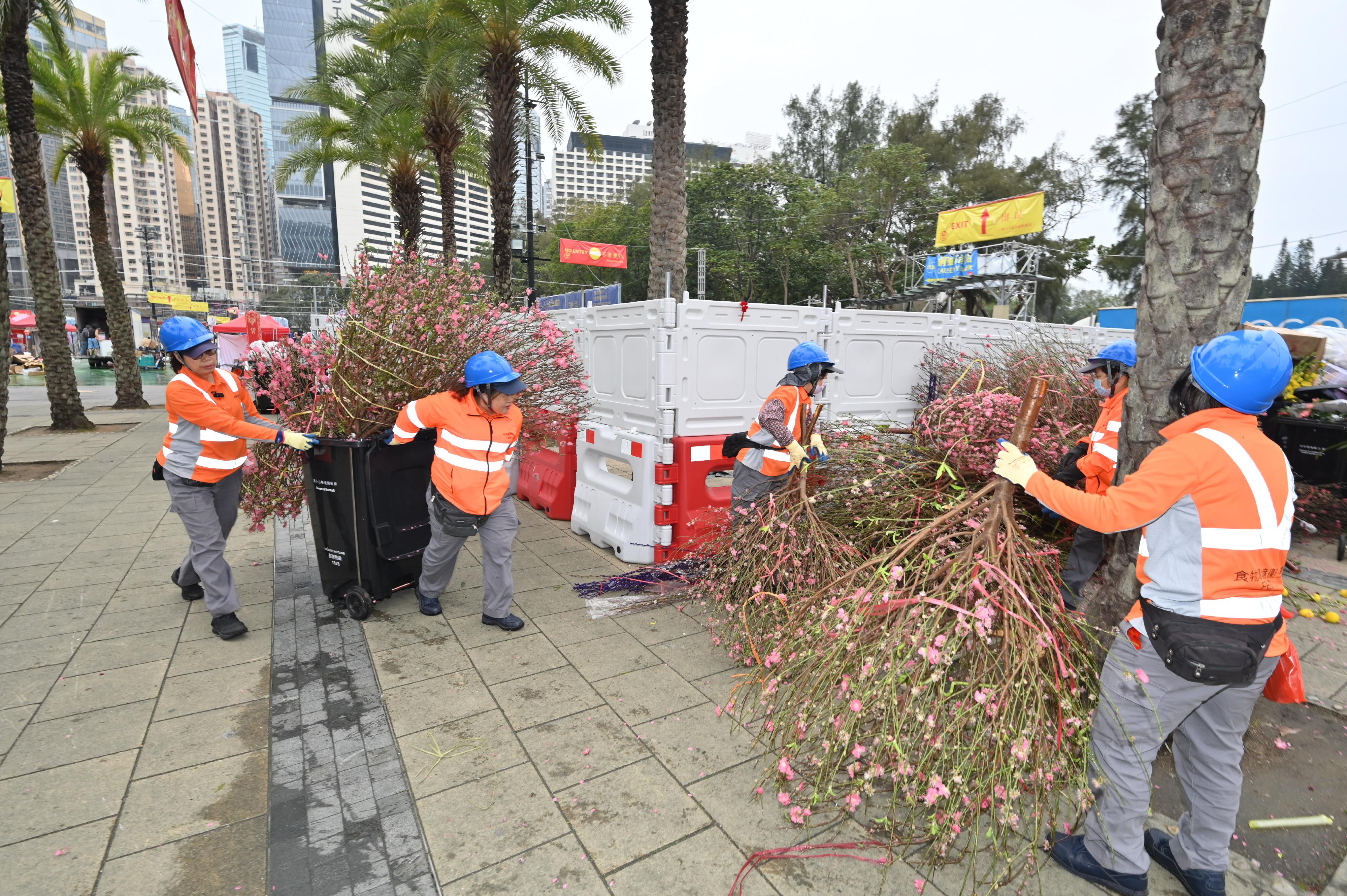 二○二四年农历年宵市场今日（二月十日）年初一清晨七时圆满结束。图示清洁工人在维多利亚公园年宵市场结束后清理场地。