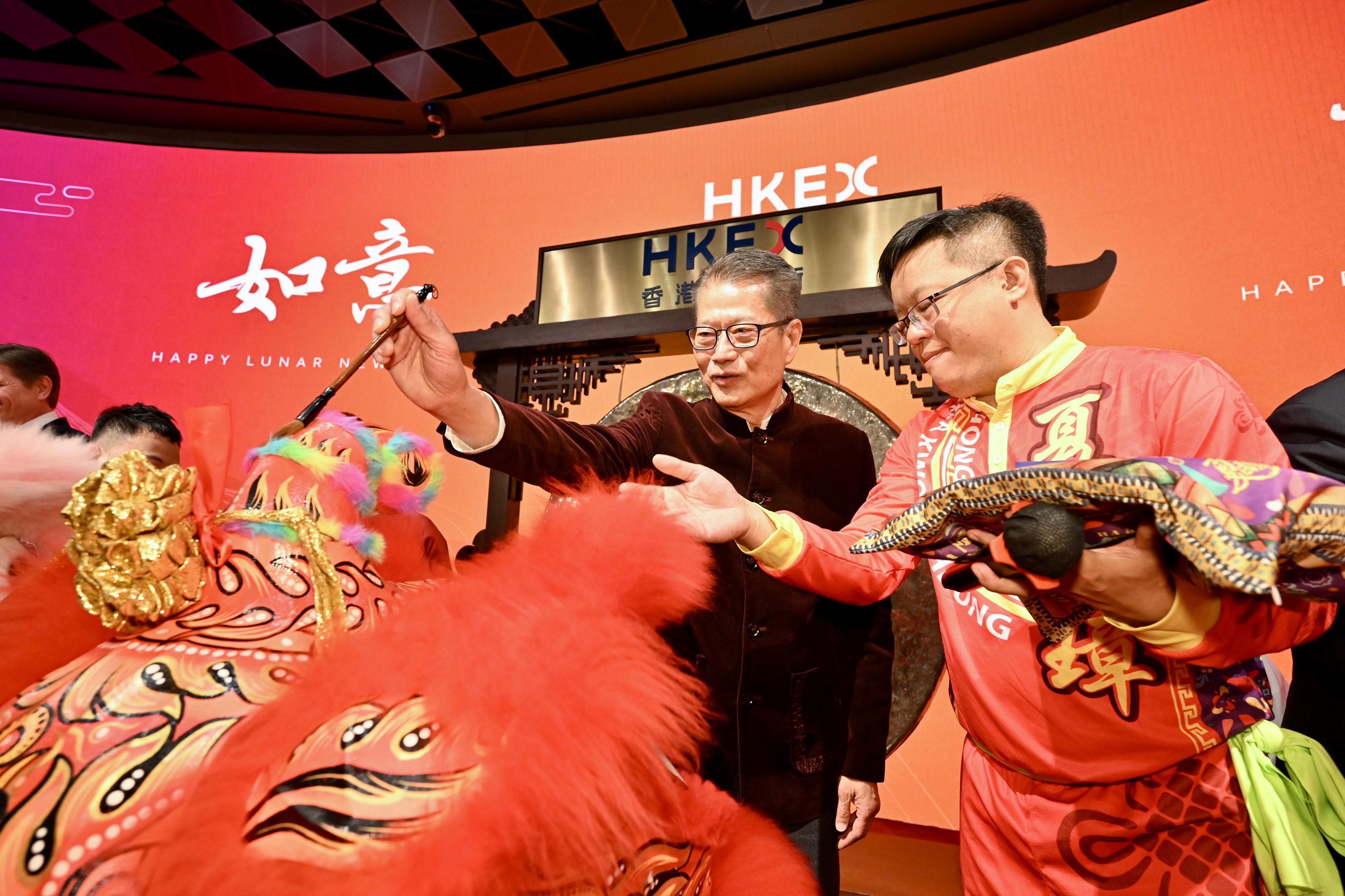 財政司司長陳茂波今日（二月十四日）出席慶賀新春開市儀式。圖示陳茂波（右二）主持醒獅點睛儀式。