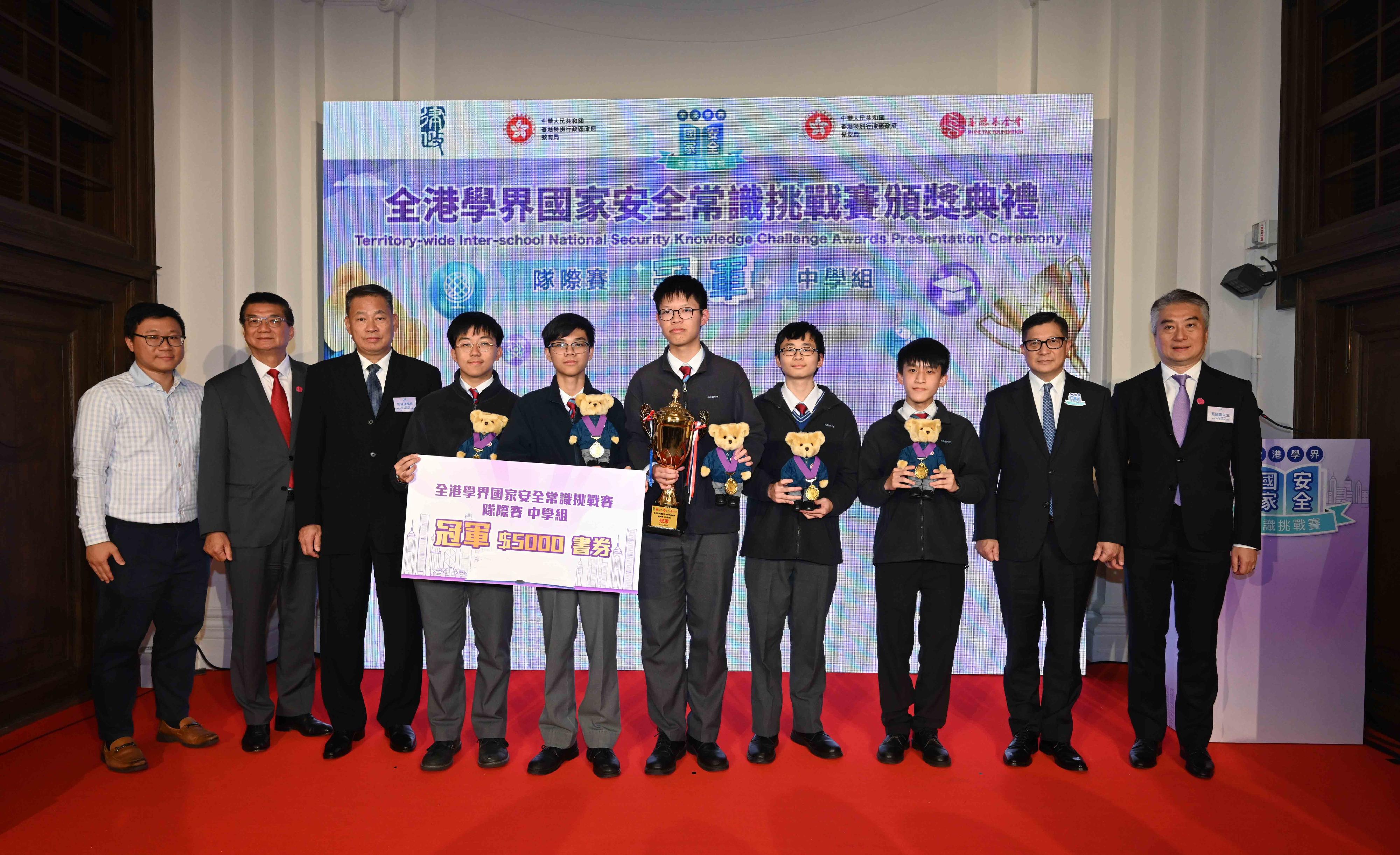 The Territory-wide Inter-school National Security Knowledge Challenge, jointly organised by the Department of Justice, the Security Bureau, the Education Bureau and the Hong Kong Shine Tak Foundation, held its finals this morning (February 26), and a prize presentation ceremony at the former French Mission Building in the afternoon. Photo shows the Secretary for Security, Mr Tang Ping-keung (second right); the Director-General of the Bureau of Liaison of the Office for Safeguarding National Security of the Central People's Government in the Hong Kong Special Administrative Region, Mr Deng Jianwei (third left); and other guests presenting the Champion award of secondary school team competition to participants from the CNEC Christian College.