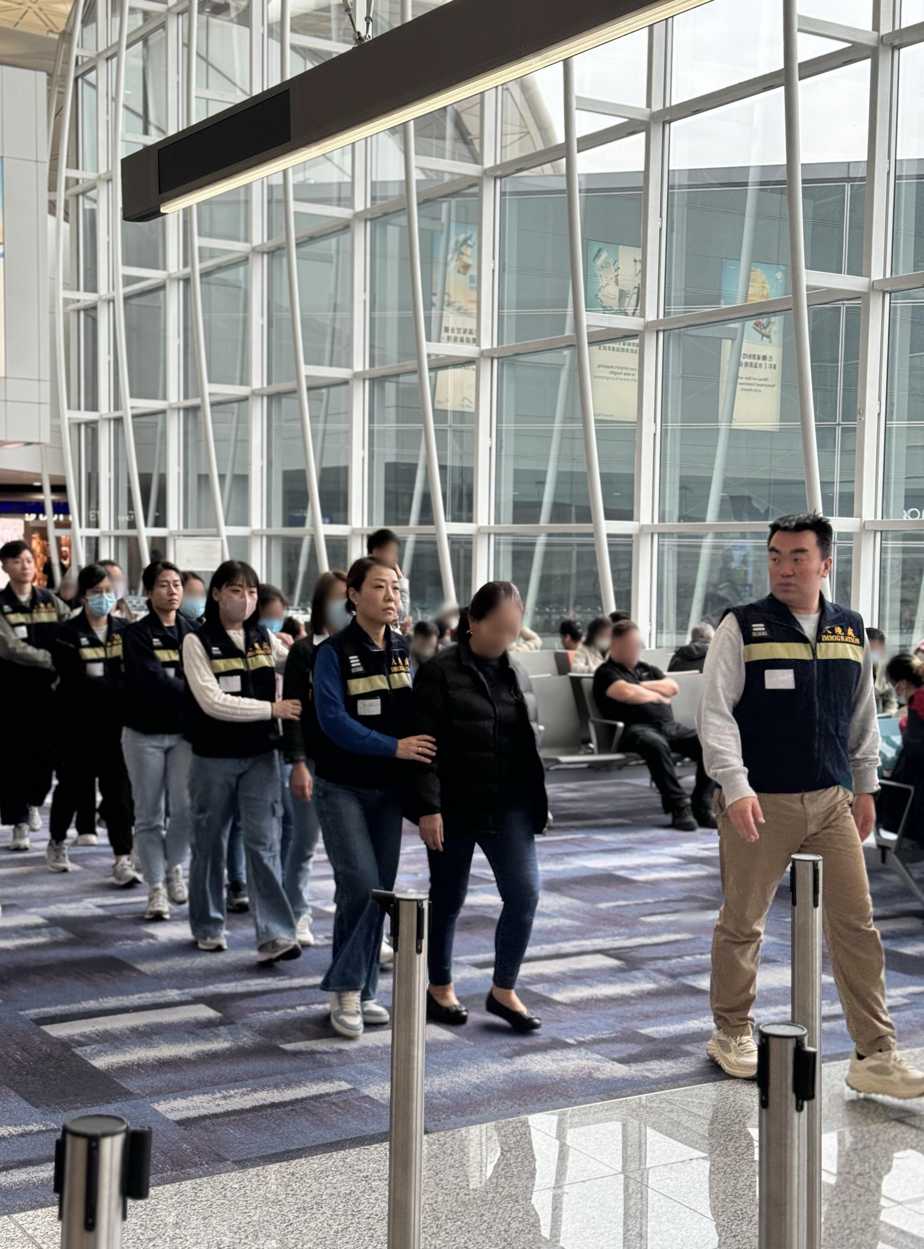 The Immigration Department (ImmD) carried out a repatriation operation today (February 27). A total of 23 Vietnamese illegal immigrants were repatriated to Vietnam. Photo shows removees being escorted by ImmD officers to depart from Hong Kong.