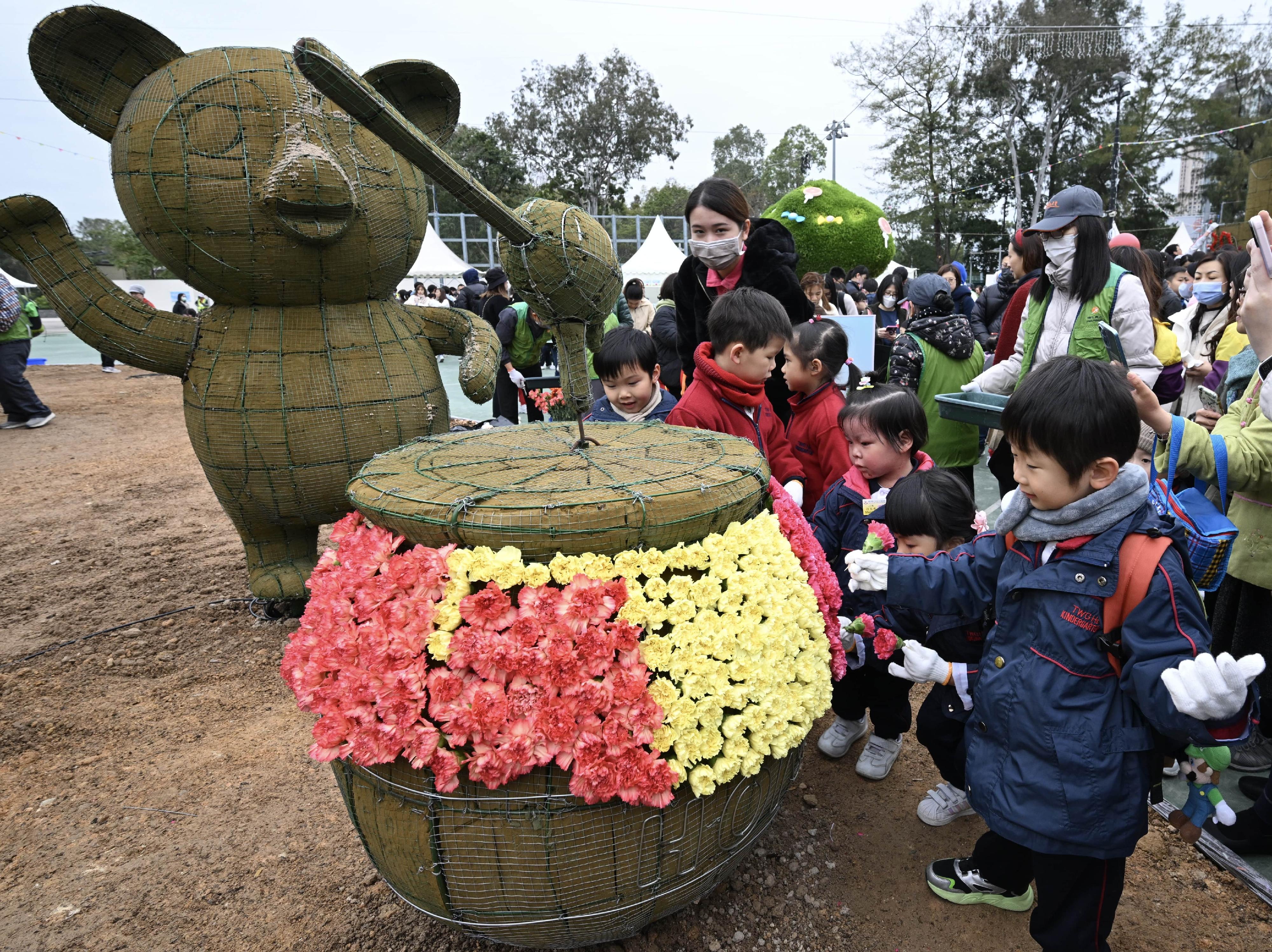 More than 1 100 students from 38 schools helped put on a spectacular horticultural display, "The Candy House", at Victoria Park today (March 2). Photo shows students in action.