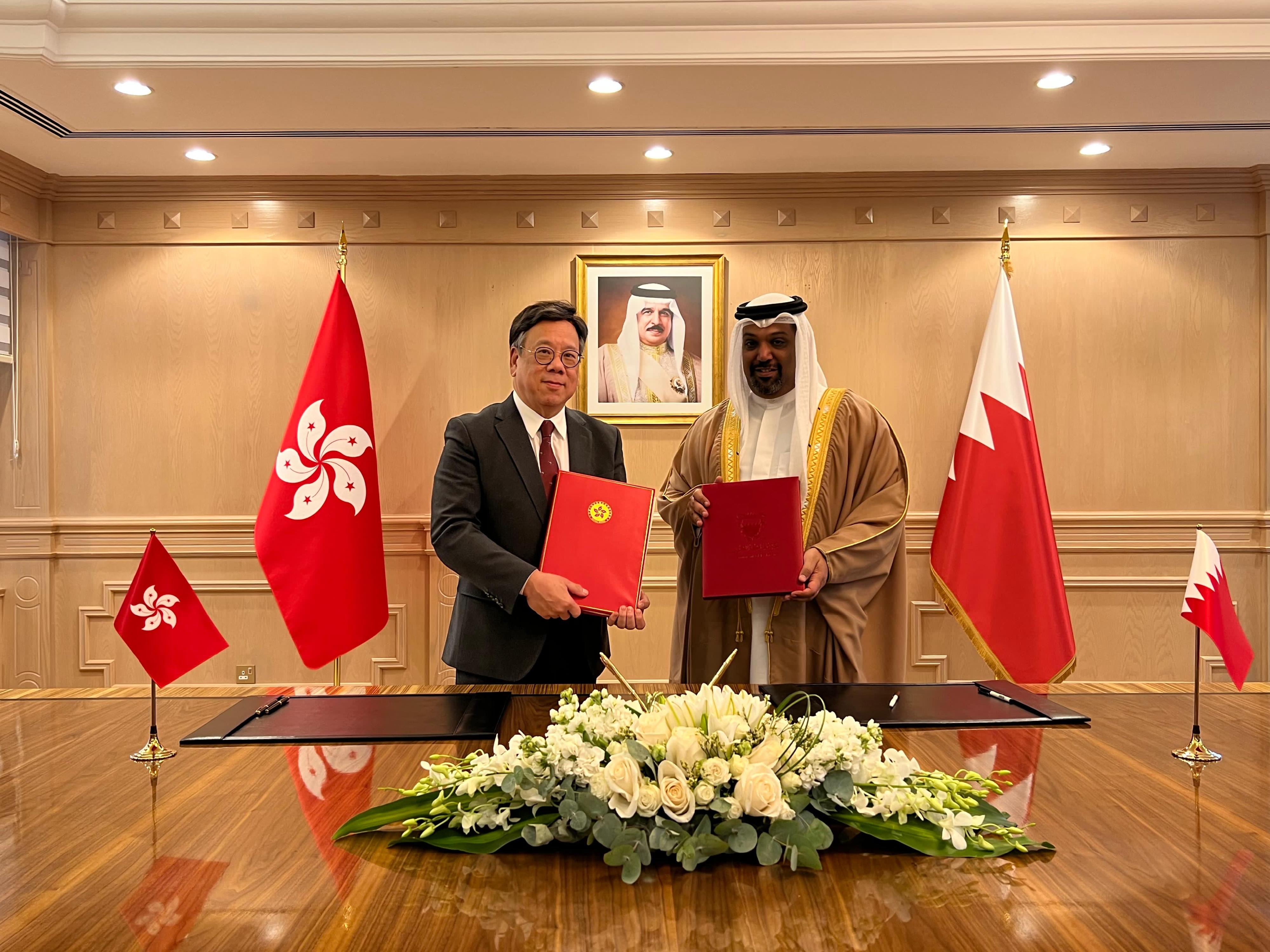 The Secretary for Commerce and Economic Development, Mr Algernon Yau (left), exchanges documents with the Minister of Finance and National Economy of Bahrain, Shaikh Salman bin Khalifa Al Khalifa (right), after signing a comprehensive avoidance of double taxation agreement yesterday (March 3, Manama time).