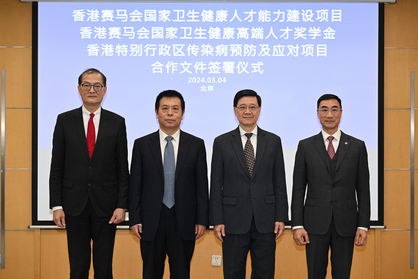The Chief Executive, Mr John Lee, attended a signing ceremony of co-operation documents in Beijing today (March 4), witnessing the signing of co-operation documents between the Hong Kong Jockey Club and the National Health Commission (NHC) and the Health Bureau respectively on strengthening the training of healthcare talent and commencing projects on the prevention and response against local communicable diseases. Photo shows Mr Lee (second right); Vice-minister of the NHC Mr Lei Haichao (second left); the Secretary for Health, Professor Lo Chung-mau (first left); and the Chairman of the Hong Kong Jockey Club, Mr Michael Lee (first right), at the ceremony.