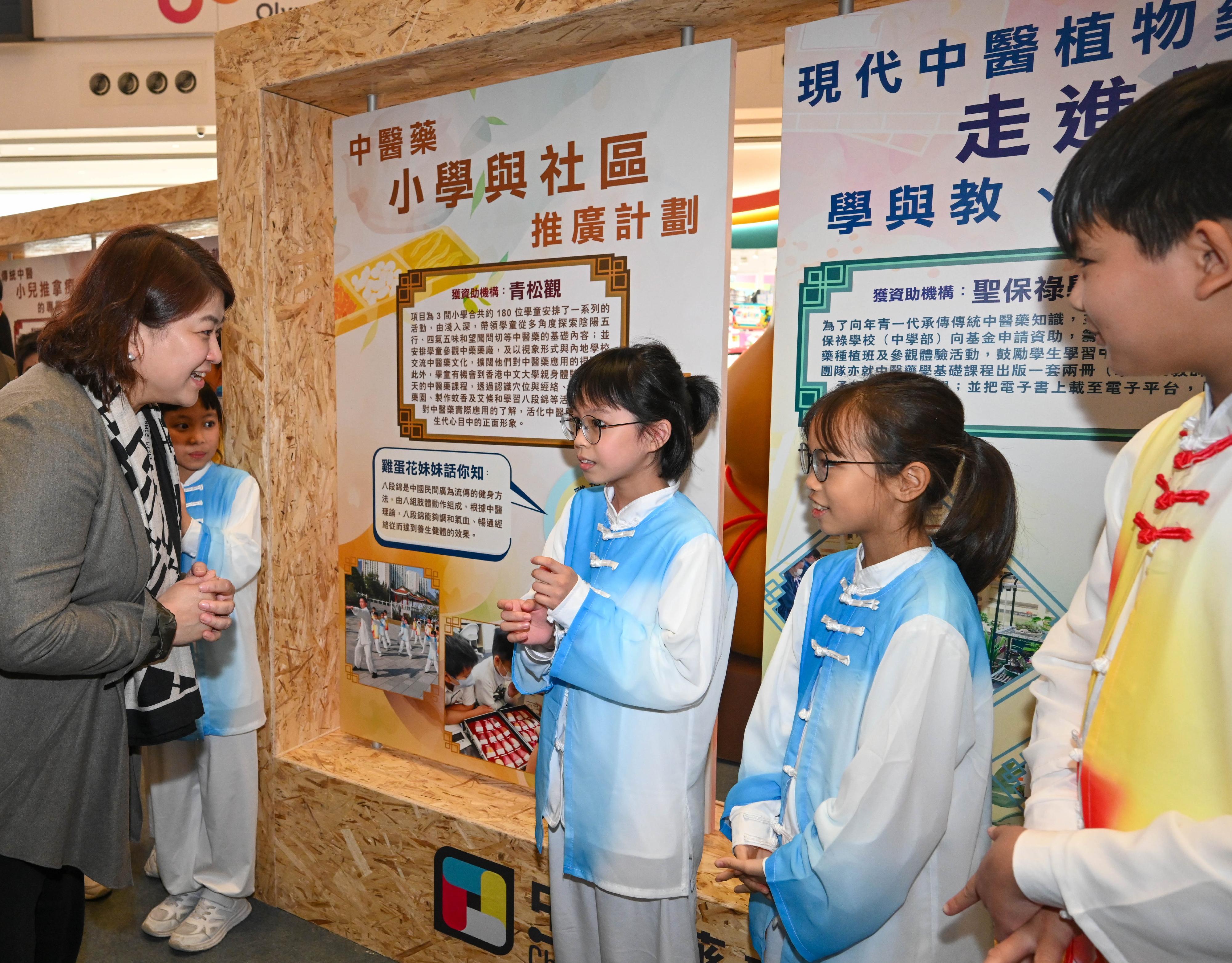 The Under Secretary for Health, Dr Libby Lee (first left), listens to a sharing by a student on a public education activity organised at her school with the support of the Chinese Medicine Development Fund (CMDF), and how she learned more about Chinese medicine through the activity, at the opening ceremony of the CMDF showcase event today (March 8).