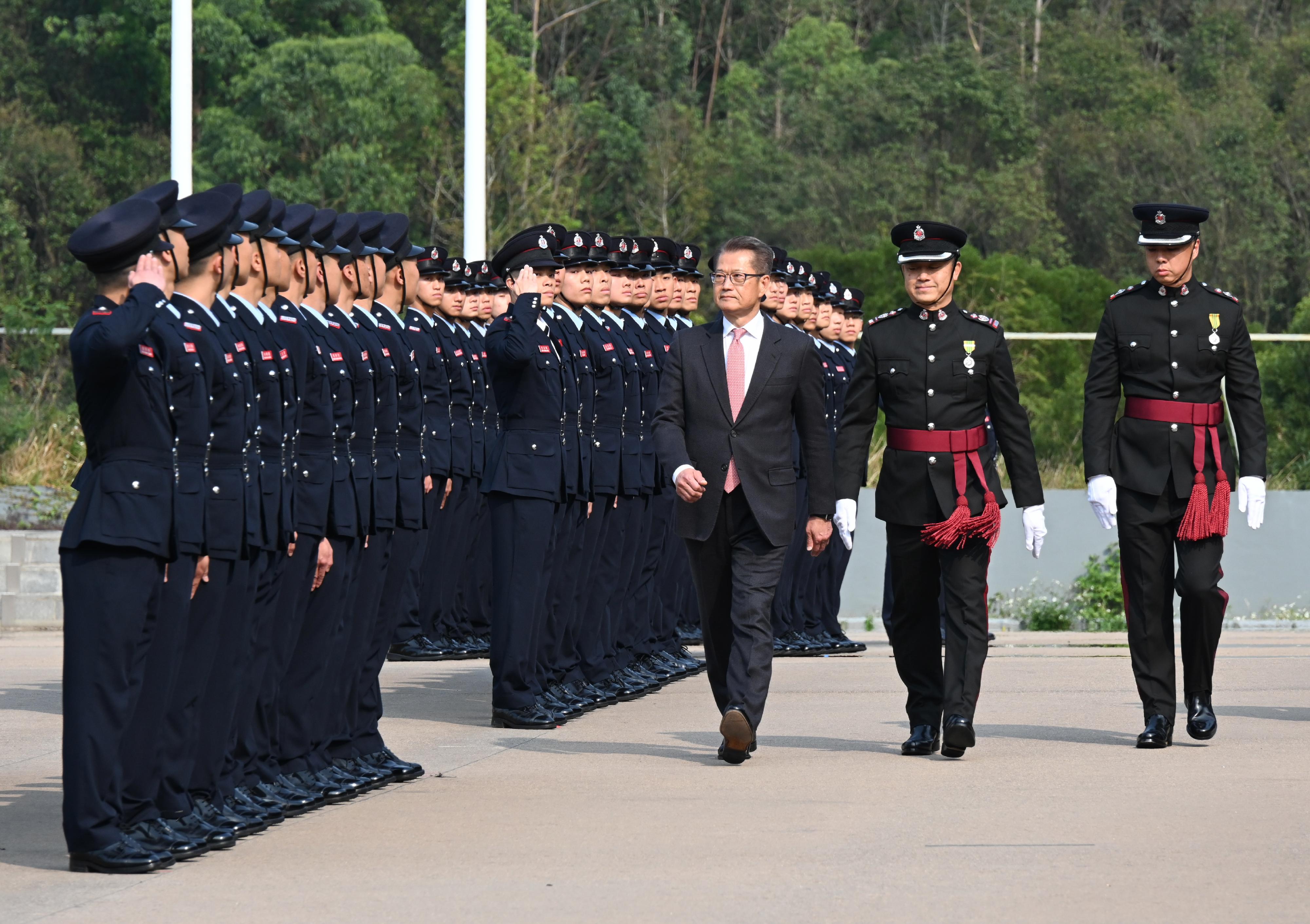 The Financial Secretary, Mr Paul Chan (third right), reviews the Fire Services passing-out parade at the Fire and Ambulance Services Academy today (March 8).