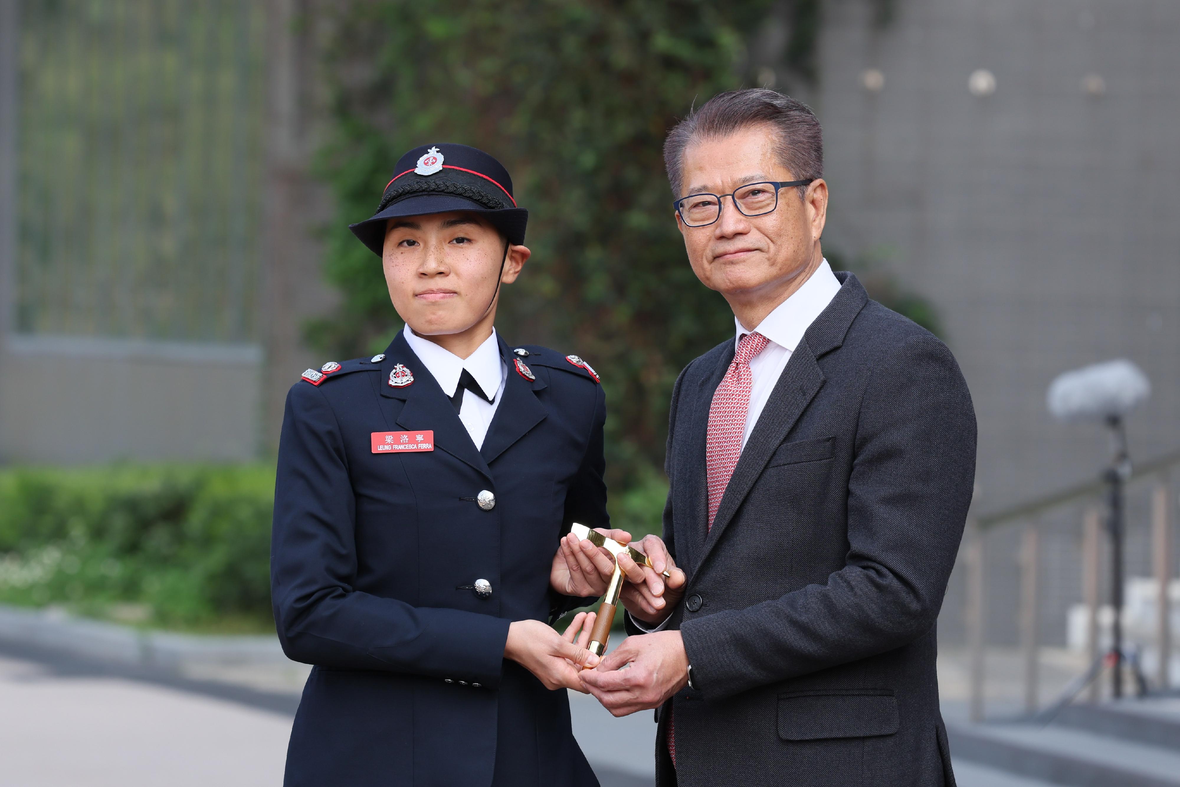 The Financial Secretary, Mr Paul Chan, reviewed the Fire Services passing-out parade at the Fire and Ambulance Services Academy today (March 8). Photo shows Mr Chan (right) presenting the Best Recruit Station Officer award to a graduate.
