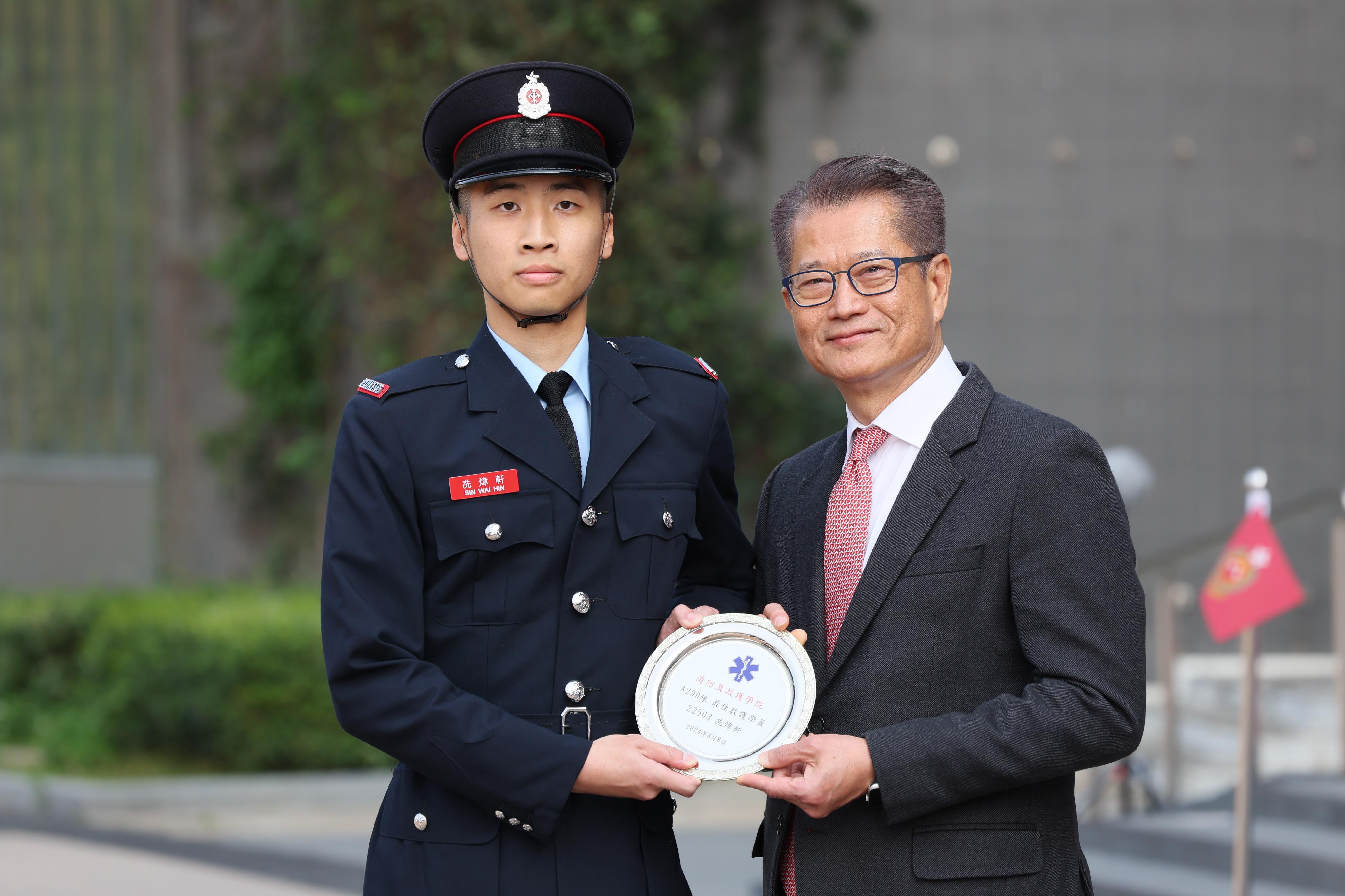 The Financial Secretary, Mr Paul Chan, reviewed the Fire Services passing-out parade at the Fire and Ambulance Services Academy today (March 8). Photo shows Mr Chan (right) presenting the Best Recruit Ambulanceman award to a graduate.

