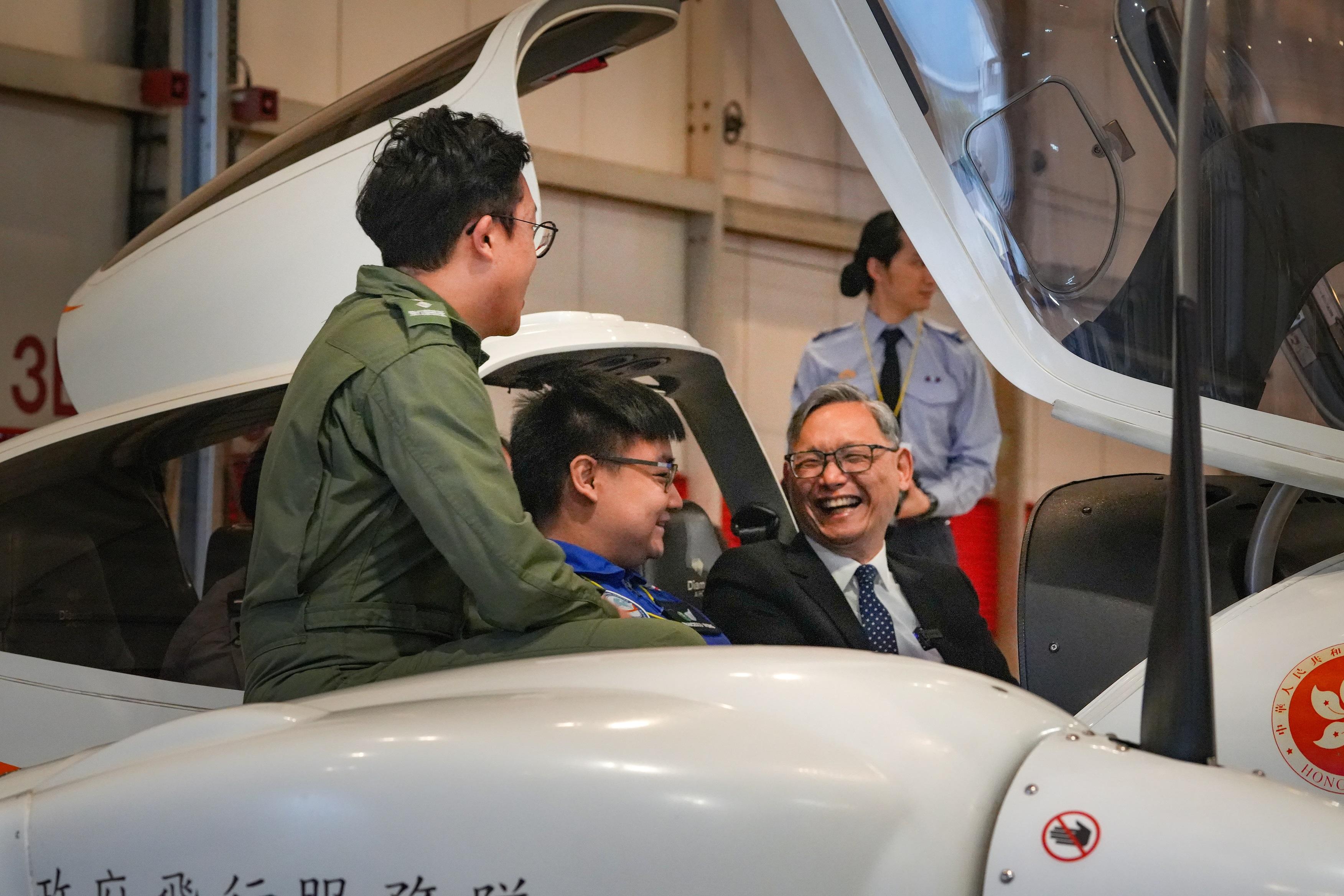 The Government Flying Service (GFS) and the Hong Kong Air Cadet Corps (HKACC) signed a Memorandum of Administrative Arrangements (MAA) today (March 9). Photo shows the Under Secretary for Security, Mr Michael Cheuk (first right) and HKACC member on a training aircraft, with GFS member conducting a brief.