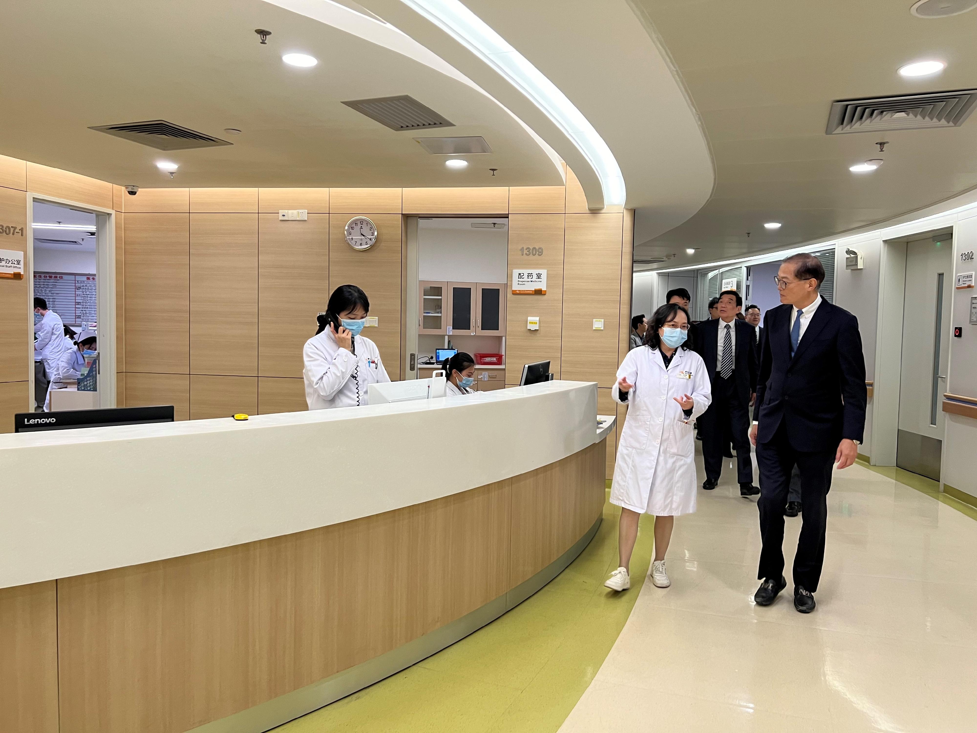 The Secretary for Health, Professor Lo Chung-mau, and his delegation visited the Zhongshan Ophthalmic Center of Sun Yat-sen University in Guangzhou today (March 13). Photo shows Professor Lo (first right) receiving a briefing by a staff member on the operation of the Center.
