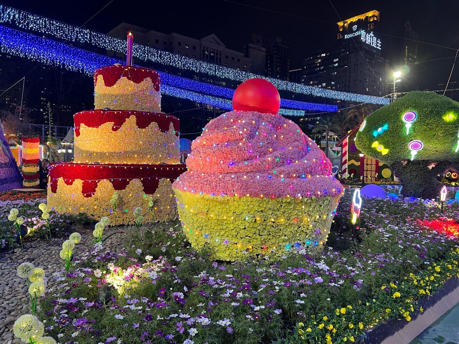 二○二四年香港花卉展覽（花展）明日（三月十五日）至三月二十四日在維多利亞公園舉行。今年花展的主題花是香彩雀，以「雀躍全城」為主題。晚上各個大型園林造景均加入燈光效果，讓遊人享受到不同的視覺體驗。圖示以《糖果屋》為主題的園林造景。
