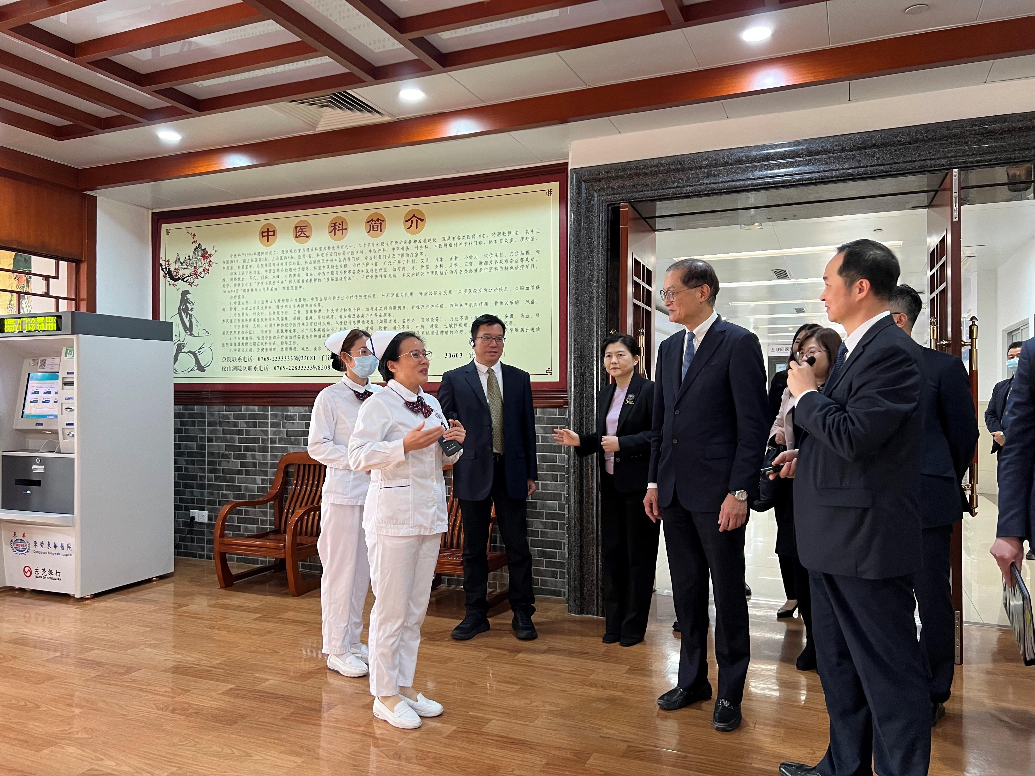 The Secretary for Health, Professor Lo Chung-mau, and his delegation visited the Dongguan Tungwah Hospital in Dongguan today (March 14). Photo shows Professor Lo (second right) receiving a briefing by a staff member on the Chinese medicine services of the hospital.