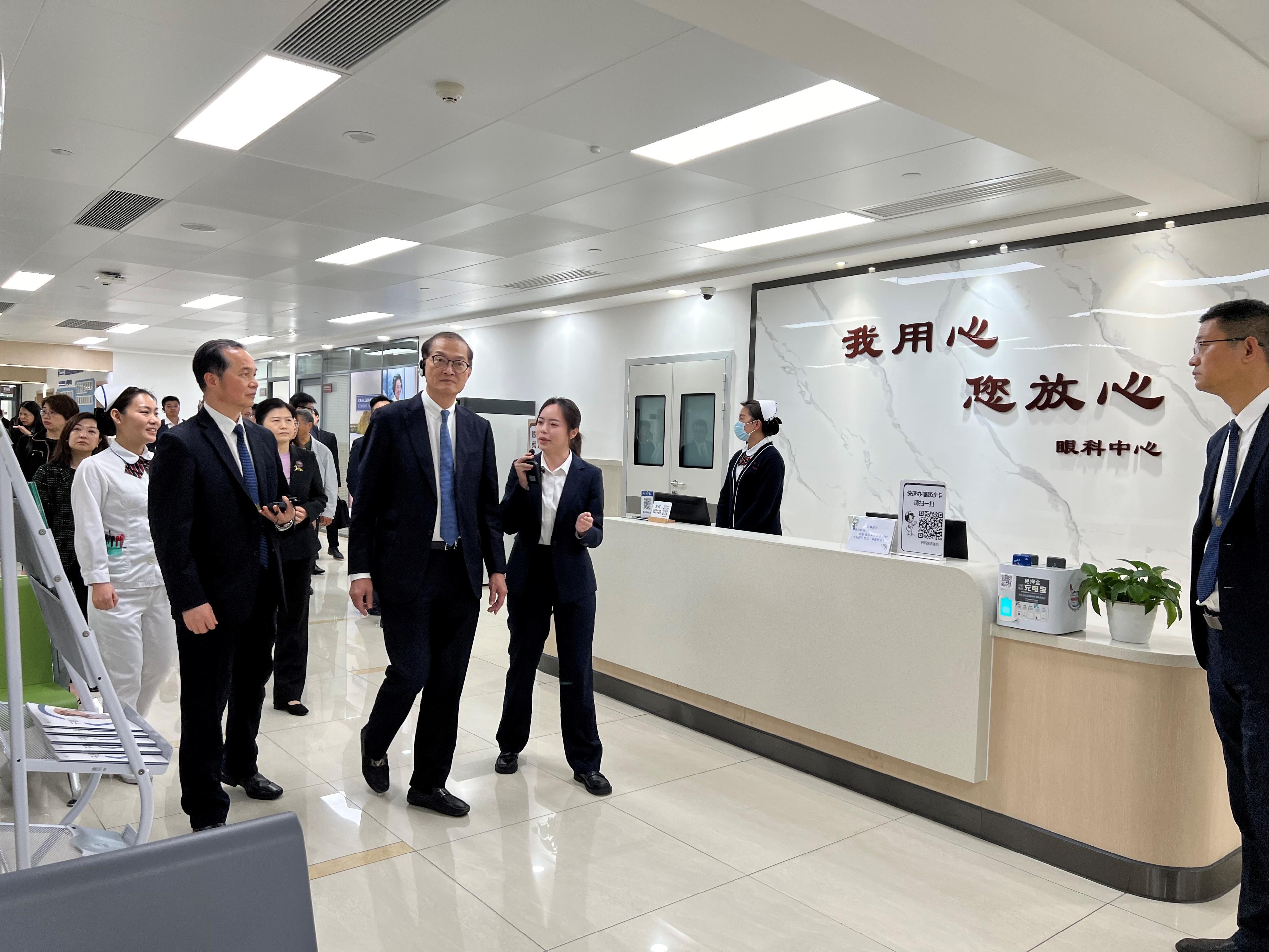 The Secretary for Health, Professor Lo Chung-mau, and his delegation visited the Dongguan Tungwah Hospital in Dongguan today (March 14). Photo shows Professor Lo (second left) receiving a briefing by a staff member on the ophthalmology services of that hospital.