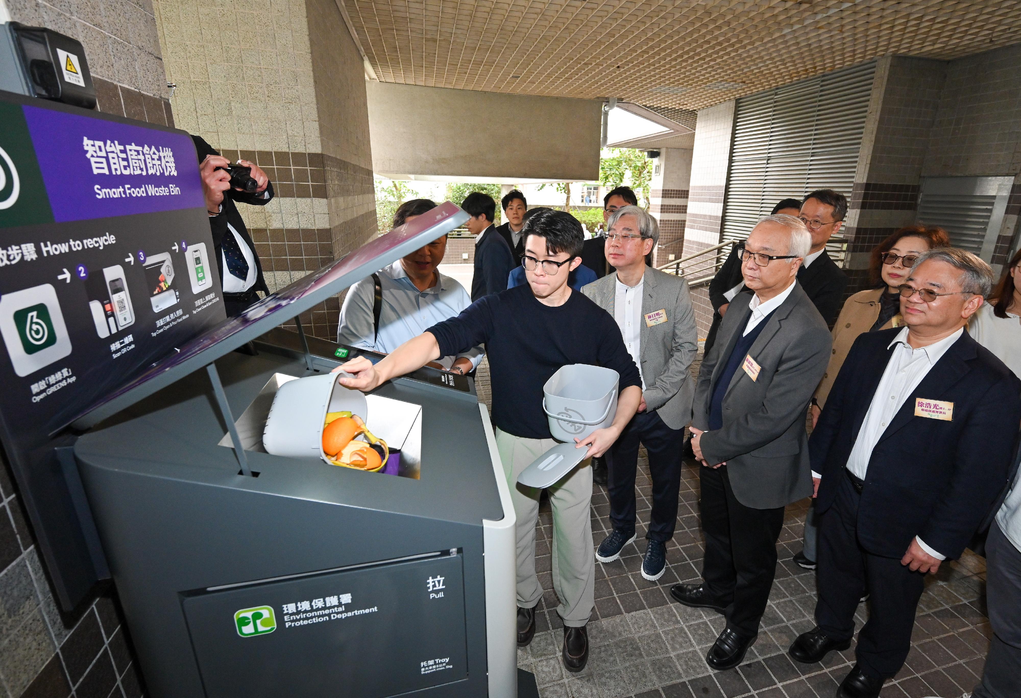 The Secretary for Environment and Ecology, Mr Tse Chin-wan, attended the launch ceremony of the Pilot Scheme on Food Waste Smart Recycling Bins in Private Housing Estates at Sceneway Garden in Lam Tin today (March 14), witnessing the introduction of the first batch of food waste smart recycling bins into large-scale private housing estates. Photo shows Mr Tse (second right); the Director of Environmental Protection, Dr Samuel Chui (first right); and the Chairman of the Estate Owners' Committee of Sceneway Garden, Mr Joe Lam (third right), watching a demonstration of using the Food Waste Smart Recycling Bin.