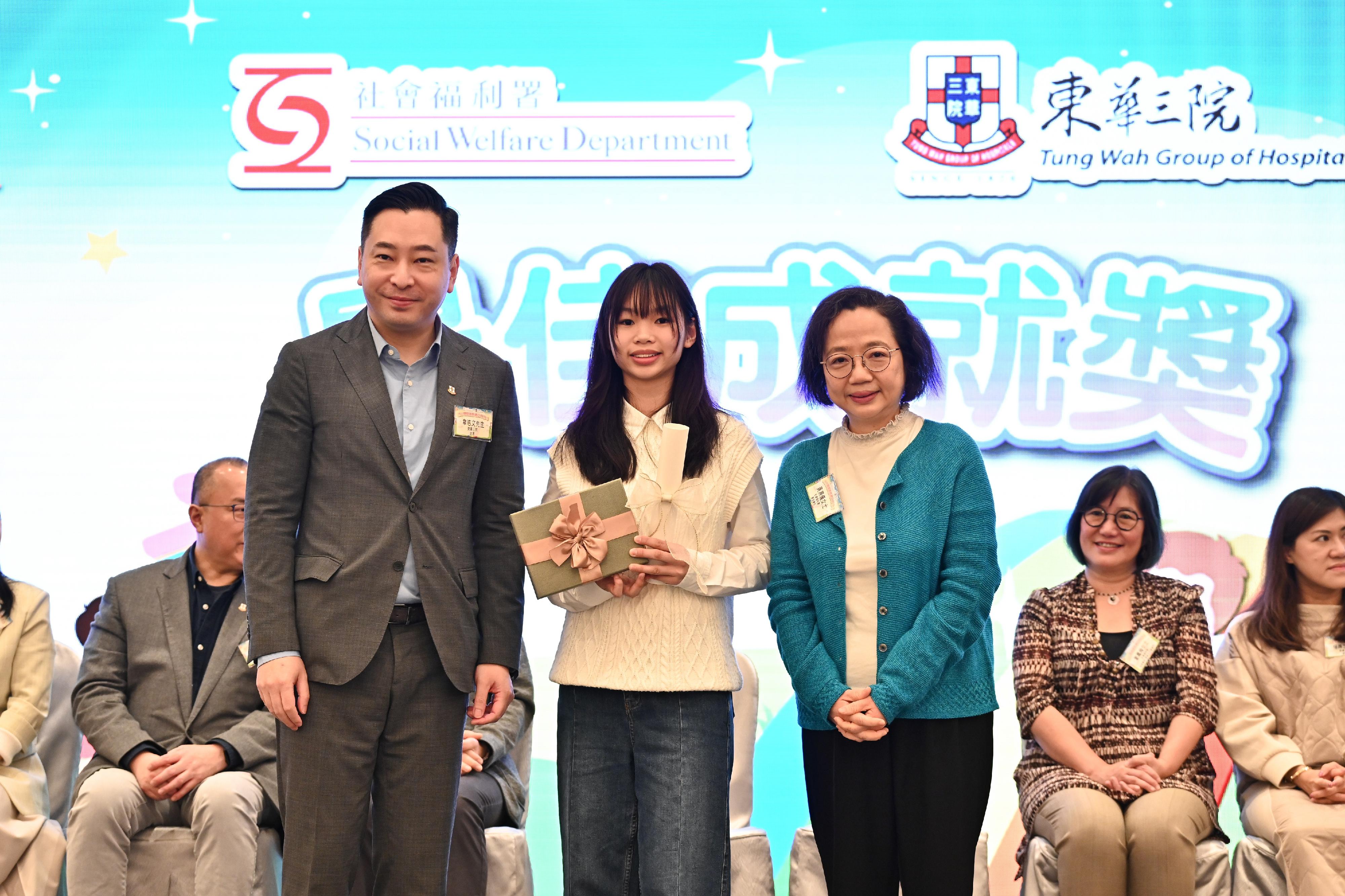 The Acting Director of Social Welfare (DSW), Ms Wong Yin-yee (right), and the Chairman of the Board of Directors of the Tung Wah Group of Hospitals, Mr Herman Wai (left), present a certificate to an awardee (centre) of the Best Achievement Award at the 2024 Award Presentation Ceremony for DSW wards today (March 16).
