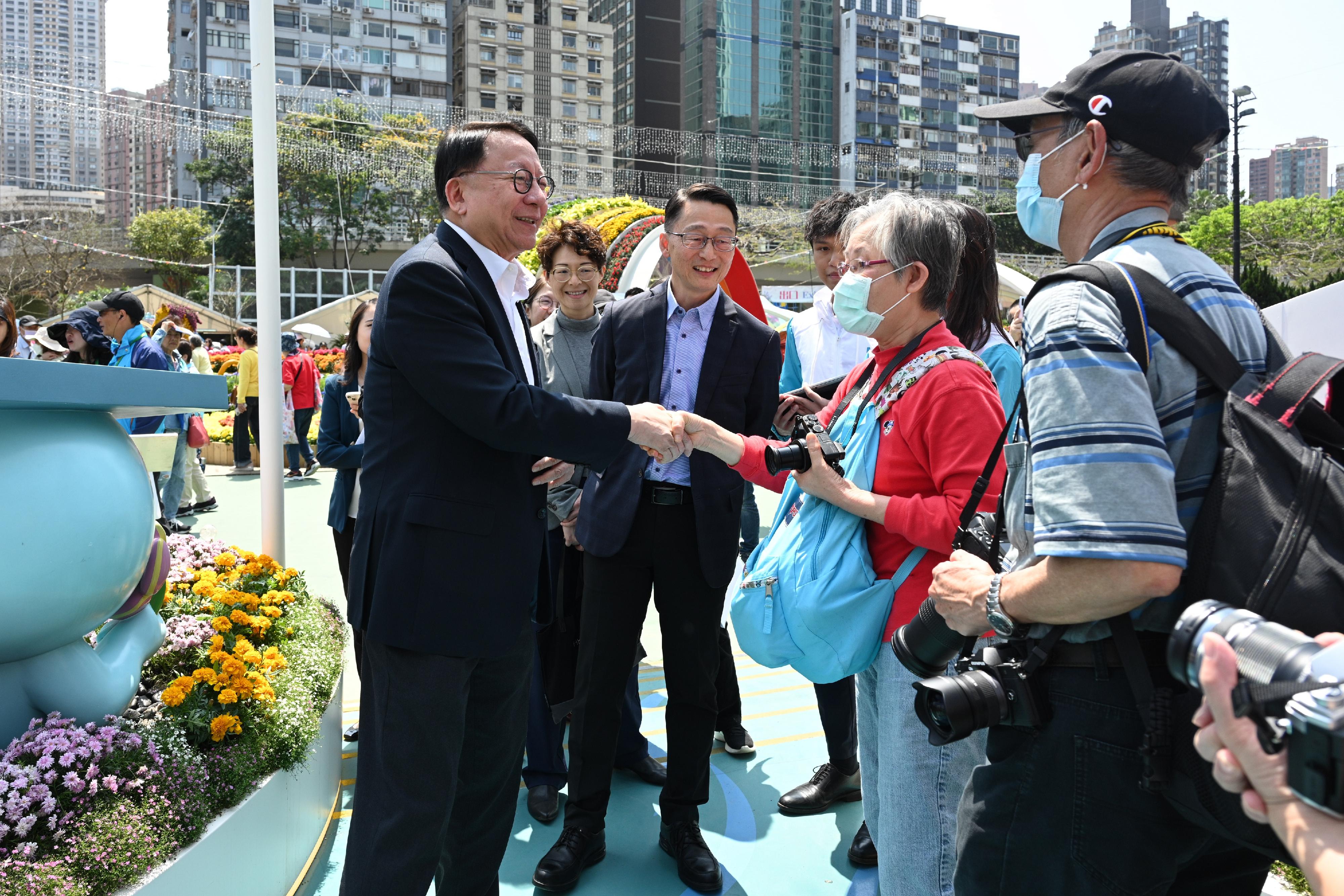 政务司司长陈国基今日（三月二十日）参观香港花卉展览2024。图示陈国基（左一）与市民交流。旁为康乐及文化事务署署长刘明光（左三）。