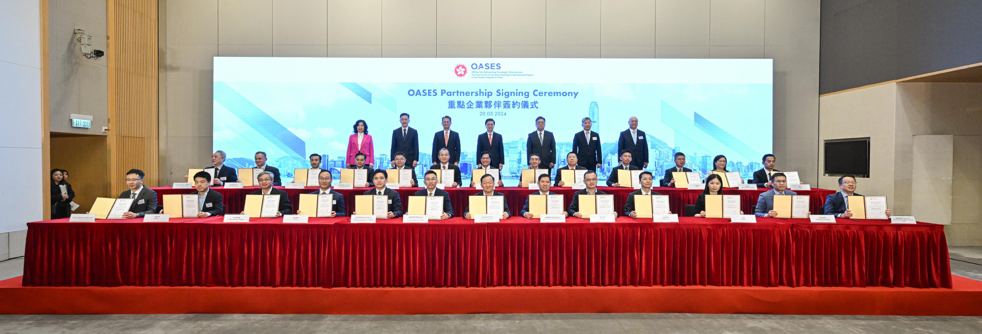 The Office for Attracting Strategic Enterprises (OASES) held the OASES Partnership Signing Ceremony today (March 20). Witnessed by the Chief Executive, Mr John Lee (third row, centre); the Financial Secretary, Mr Paul Chan (third row, third left), and other relevant Principal Officials, the partnership agreement was signed by the Deputy Financial Secretary, Mr Michael Wong (second row, centre), and representatives of the strategic enterprises.
