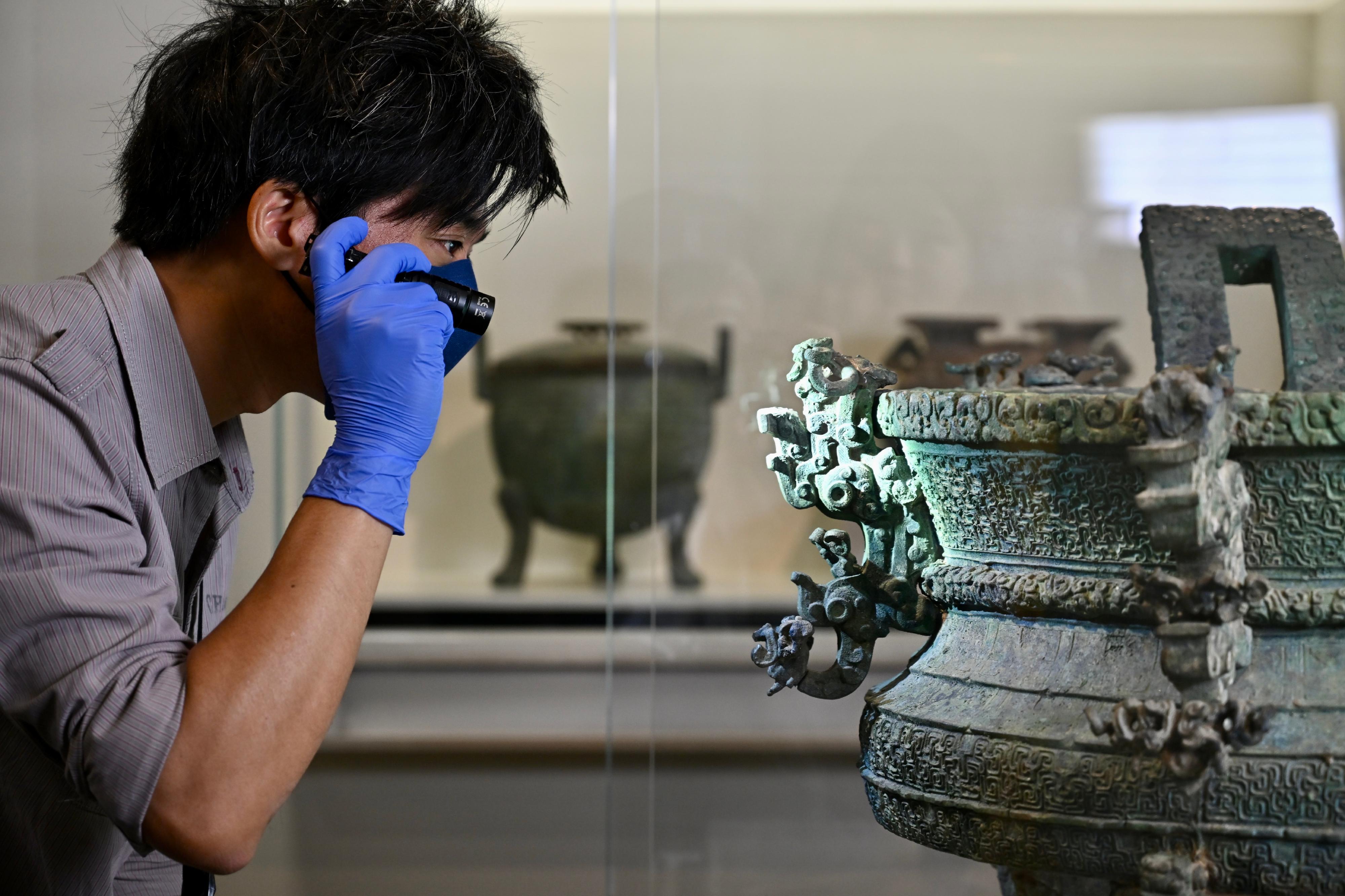 The Hong Kong Museum of History will launch the first exhibition of the General History of China Exhibition Series in collaboration with the Chinese Culture Promotion Office, "The Hong Kong Jockey Club Series: The Ancient Civilisation of the Xia, Shang and Zhou Dynasties in Henan Province" exhibition on April 3, to showcase over 150 sets of cultural relics from the collections of the Henan Museum, as well as a dozen other museums and cultural institutions in the province. Invaluable cultural relics have arrived in Hong Kong. Photo shows a museum conservator performing condition inspection for an artefact.