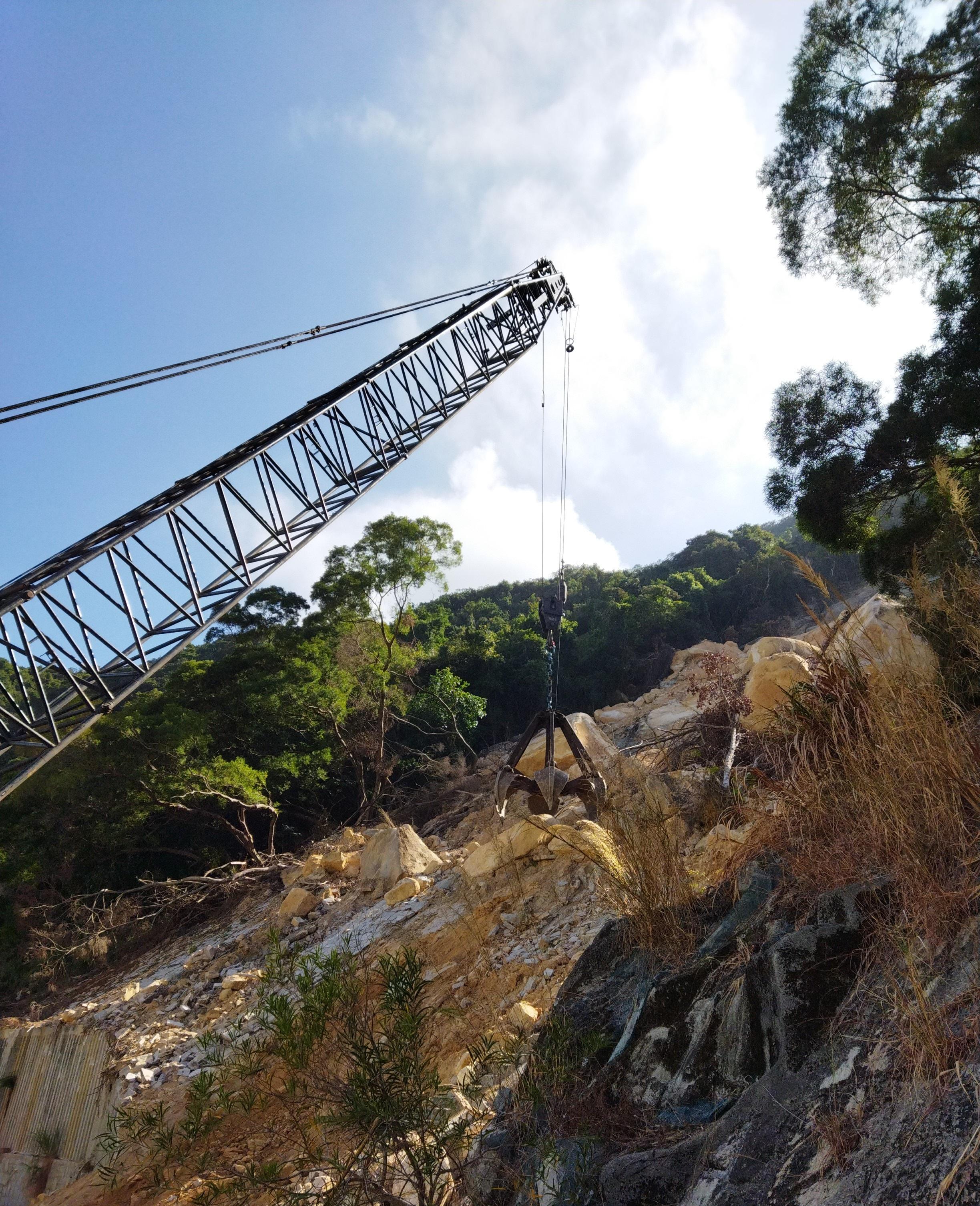 The Highways Department today (March 21) said that a section of the westbound traffic lane at Yiu Hing Road will be reopened on March 23. Photo shows the removal of boulders on the slope by a large crane earlier at the scene, which formed part of the repair works for the natural slope above Yiu Hing Road.